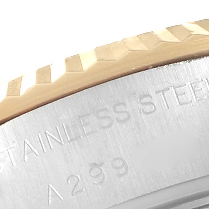 This close-up angle shows part of the bezel and case back of a Rolex Datejust 79173 Women's Steel and Gold (two tone) Champagne Dial 79173 Women's Steel and Gold (two tone) Champagne Dial watch, highlighting the fluted bezel and part of the engraved text.