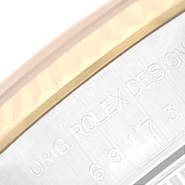 The image shows a close-up angle of the side with engraved text and yellow bezel of a Rolex Datejust 69173 Women's Steel and Gold (two tone) Blue Dial 69173 Women's Steel and Gold (two tone) Blue Dial watch.