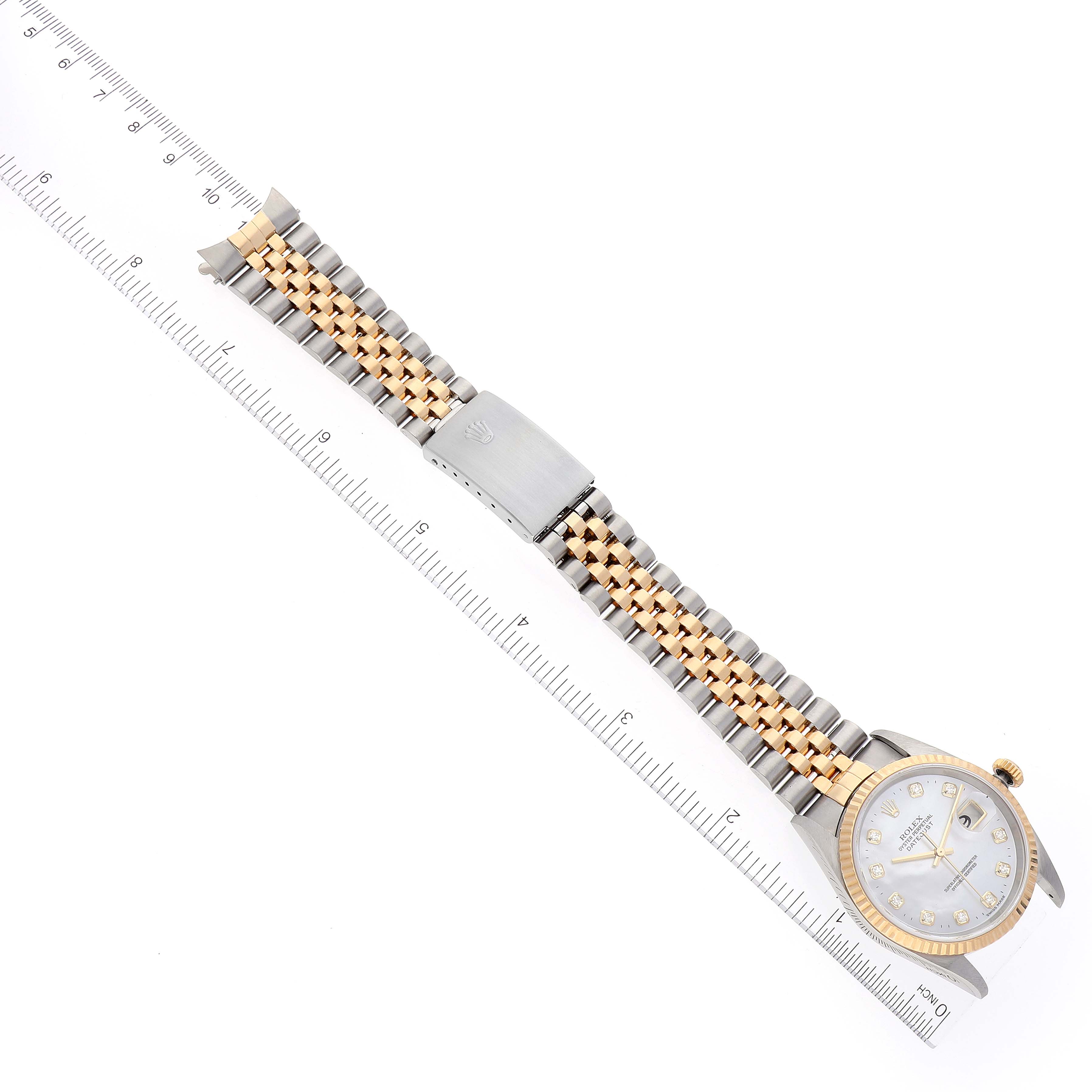 The image shows a Rolex Datejust 16233 Men's Steel and Gold (two tone) Mother of Pearl Dial 16233 Men's Steel and Gold (two tone) Mother of Pearl Dial watch placed next to a ruler, showcasing its full length, bracelet, clasp, and face.