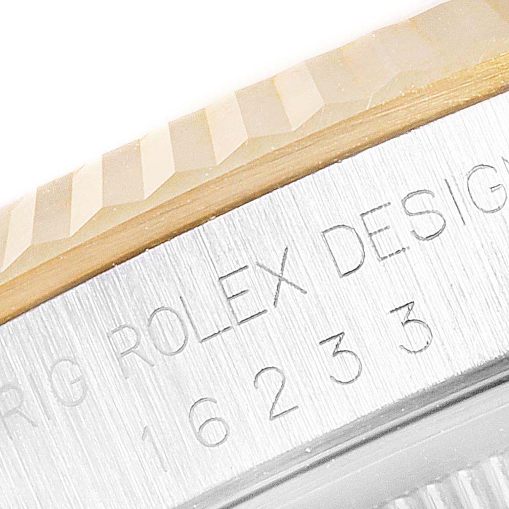 The image shows a close-up of the fluted bezel and part of the case-side engraving on a Rolex Datejust 16233 Men's Steel and Gold (two tone) Silver Dial 16233 Men's Steel and Gold (two tone) Silver Dial model.