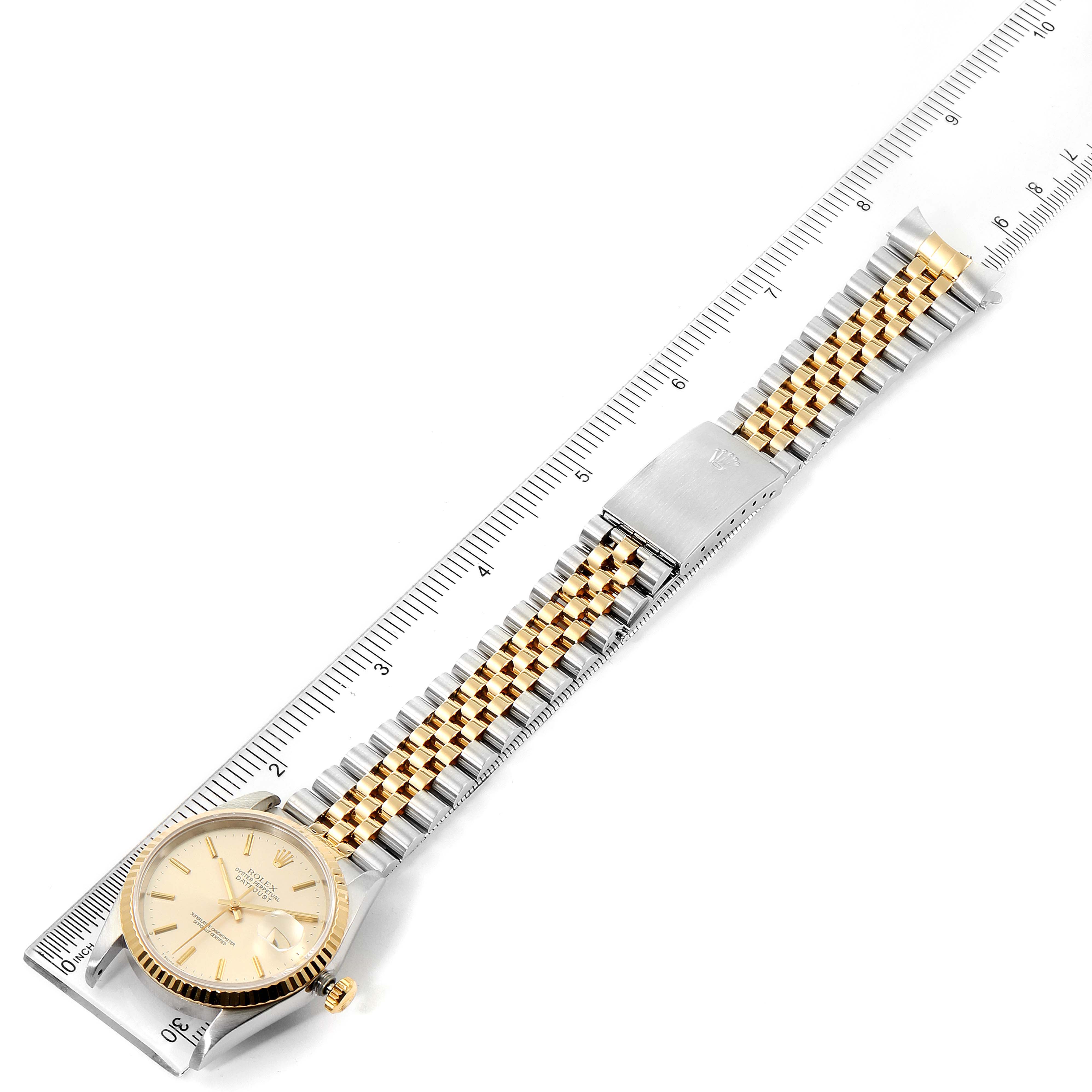 The image shows a Rolex Datejust 16233 Men's Steel and Gold (two tone) Silver Dial 16233 Men's Steel and Gold (two tone) Silver Dial watch laid flat with its face and bracelet fully visible, next to a measuring ruler for scale.