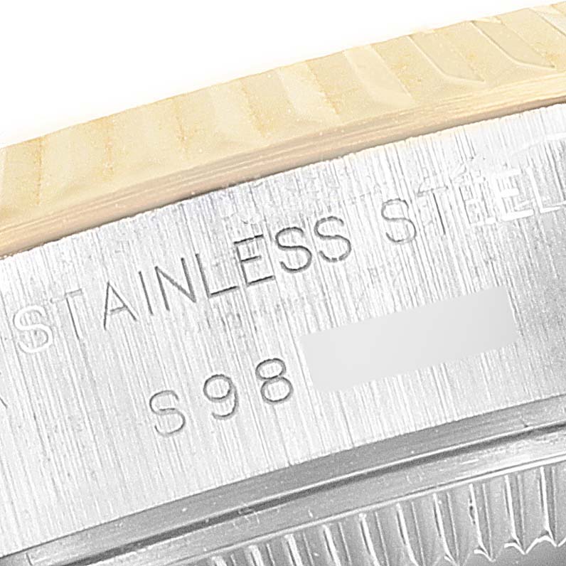 The image shows a close-up of the side engravings and fluted bezel of a Rolex Datejust 69173 Women's Steel and Gold (two tone) White Dial 69173 Women's Steel and Gold (two tone) White Dial watch.