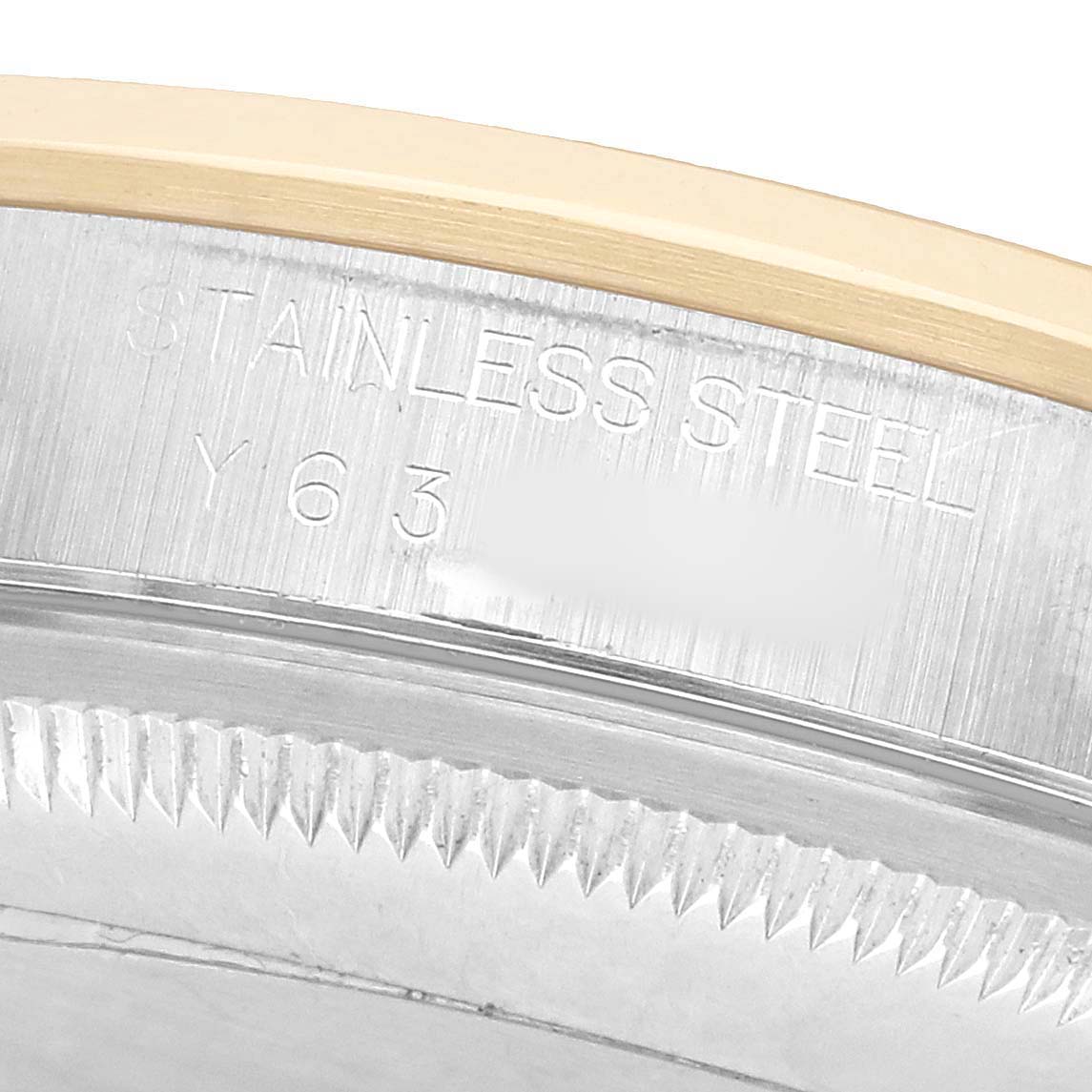 The image shows a close-up of the case edge and part of the fluted bezel of a Rolex Datejust 16203 Men's Steel and Gold (two tone) White Dial watch, highlighting the stainless steel engraving.