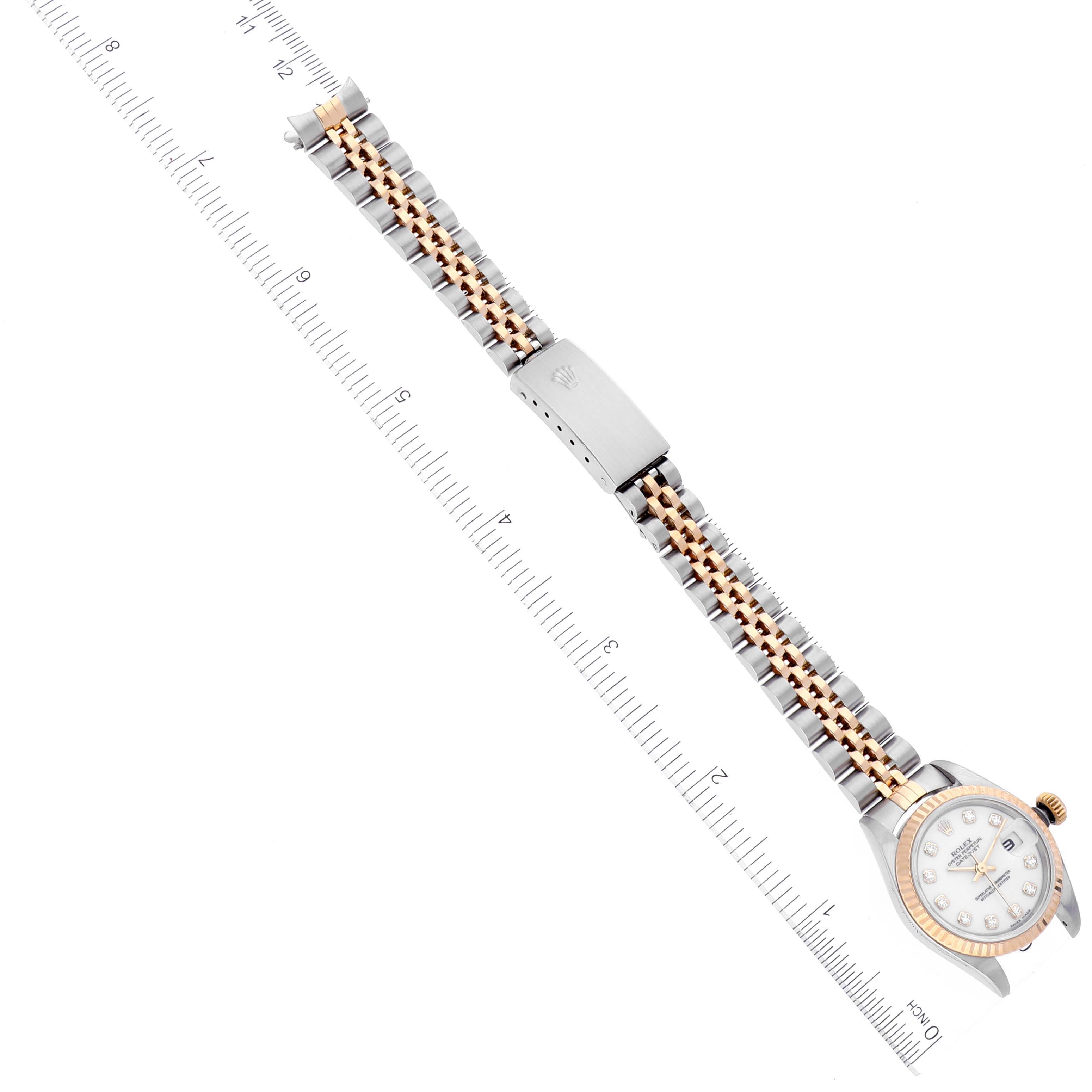 The Rolex Datejust 79173 Women's Steel and Gold (two tone) White Dial 79173 Women's Steel and Gold (two tone) White Dial watch is shown laid flat with a clearly visible dial, bezel, and two-tone bracelet, alongside a ruler for scale.