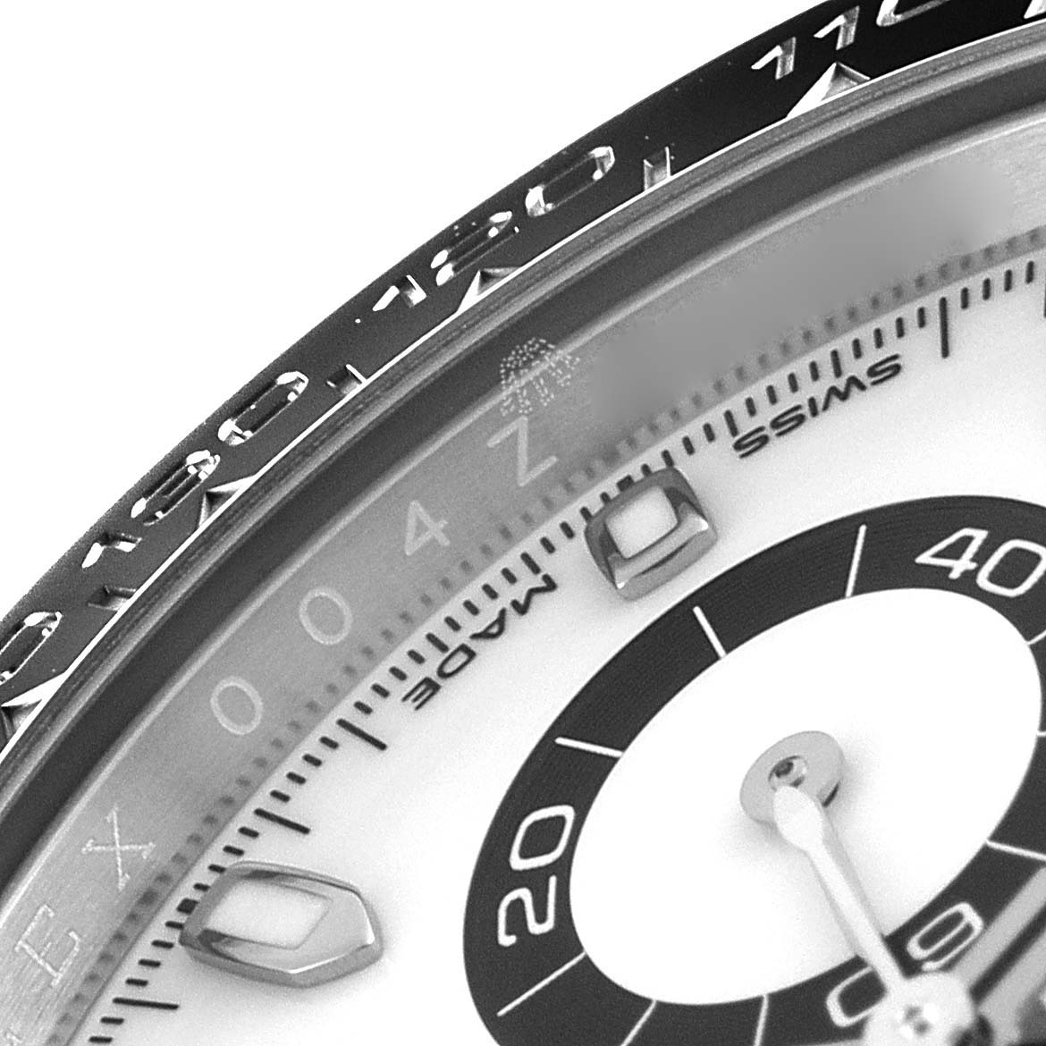 The image shows a close-up of the bezel and dial of a Rolex Daytona 116500 Men's Stainless Steel White Dial 116500 Men's Stainless Steel White Dial watch, highlighting the hour markers and part of the minute track.