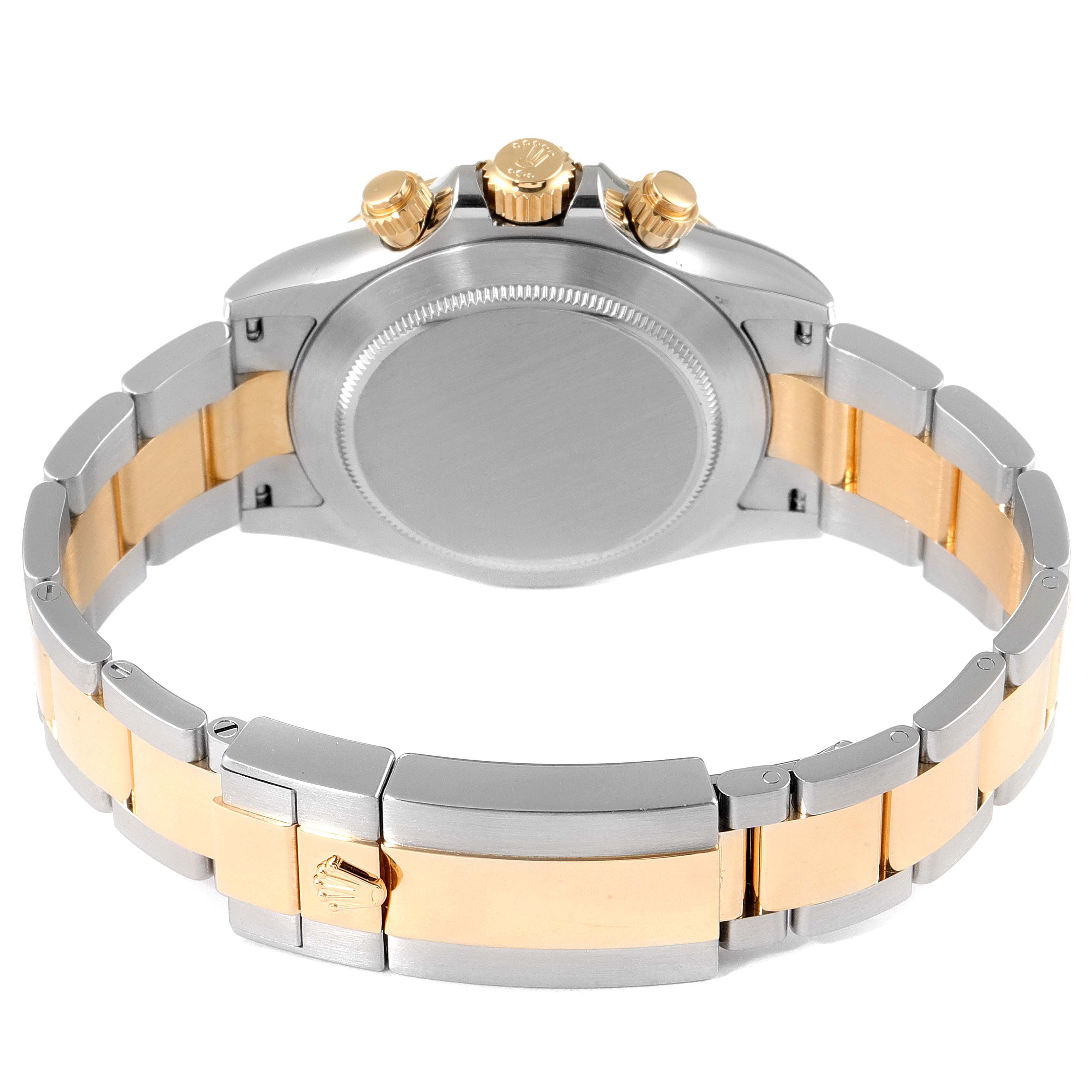 The image shows the back view of a Rolex Daytona 116523 Men's Steel and Gold (two tone) Mother of Pearl Dial 116523 Men's Steel and Gold (two tone) Mother of Pearl Dial watch, highlighting its two-tone bracelet and the crown.