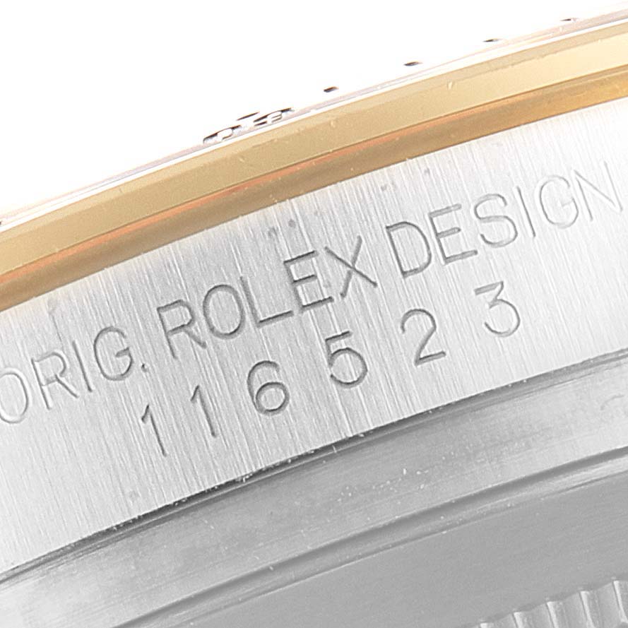This image shows an angled close-up of the model number and brand engraving on the case of a Rolex Daytona 116523 Men's Steel and Gold (two tone) Mother of Pearl Dial 116523 Men's Steel and Gold (two tone) Mother of Pearl Dial watch.