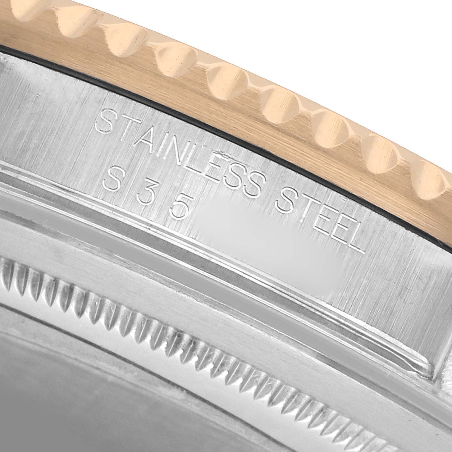 The image shows a close-up of the Rolex GMT-Master 16713 Men's Steel and Gold (two tone) Black Dial watch's case side, highlighting the stainless steel engraving and part of the bezel.