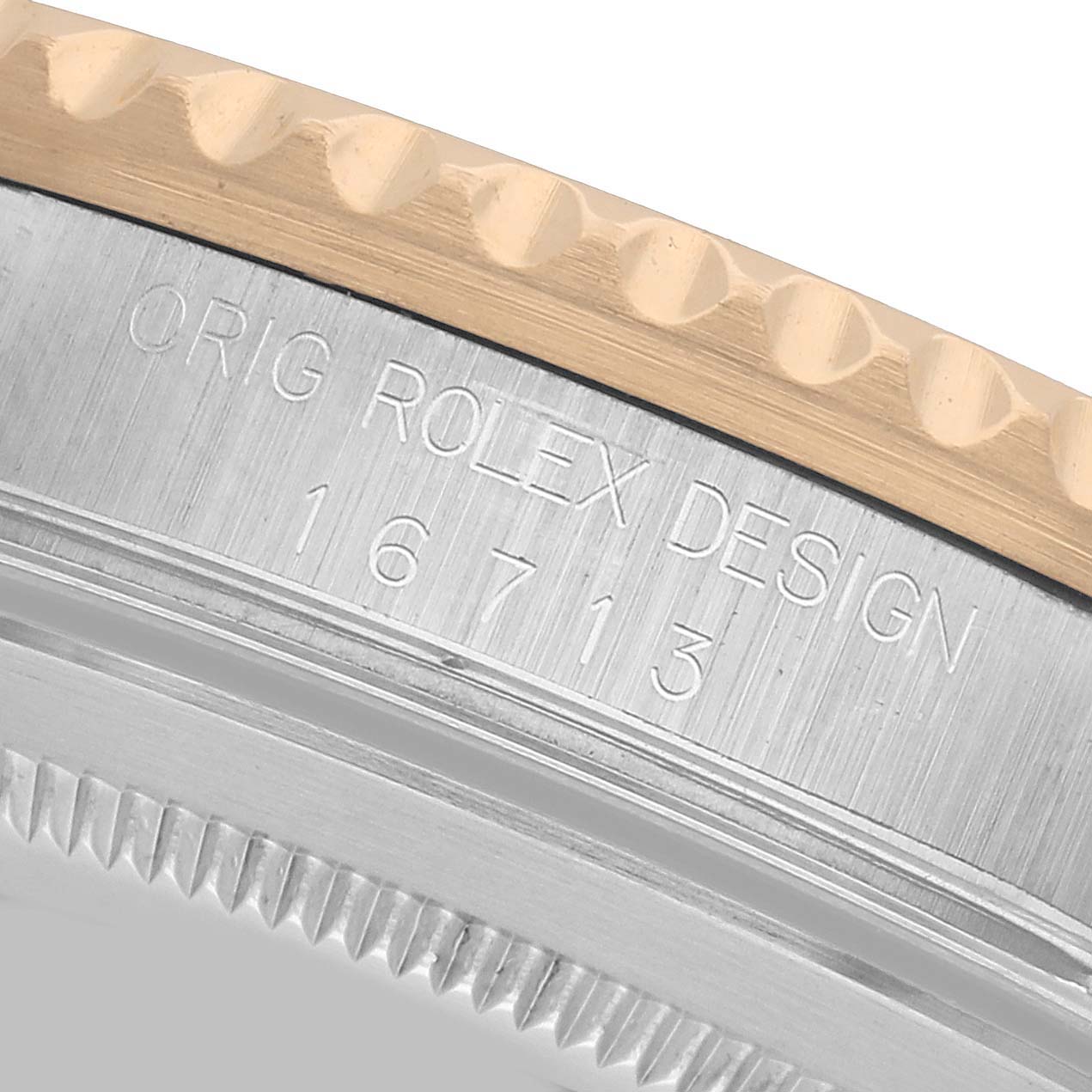 The image shows a close-up of the bezel and case with model number engraving on the Rolex GMT-Master 16713 Men's Steel and Gold (two tone) Black Dial.