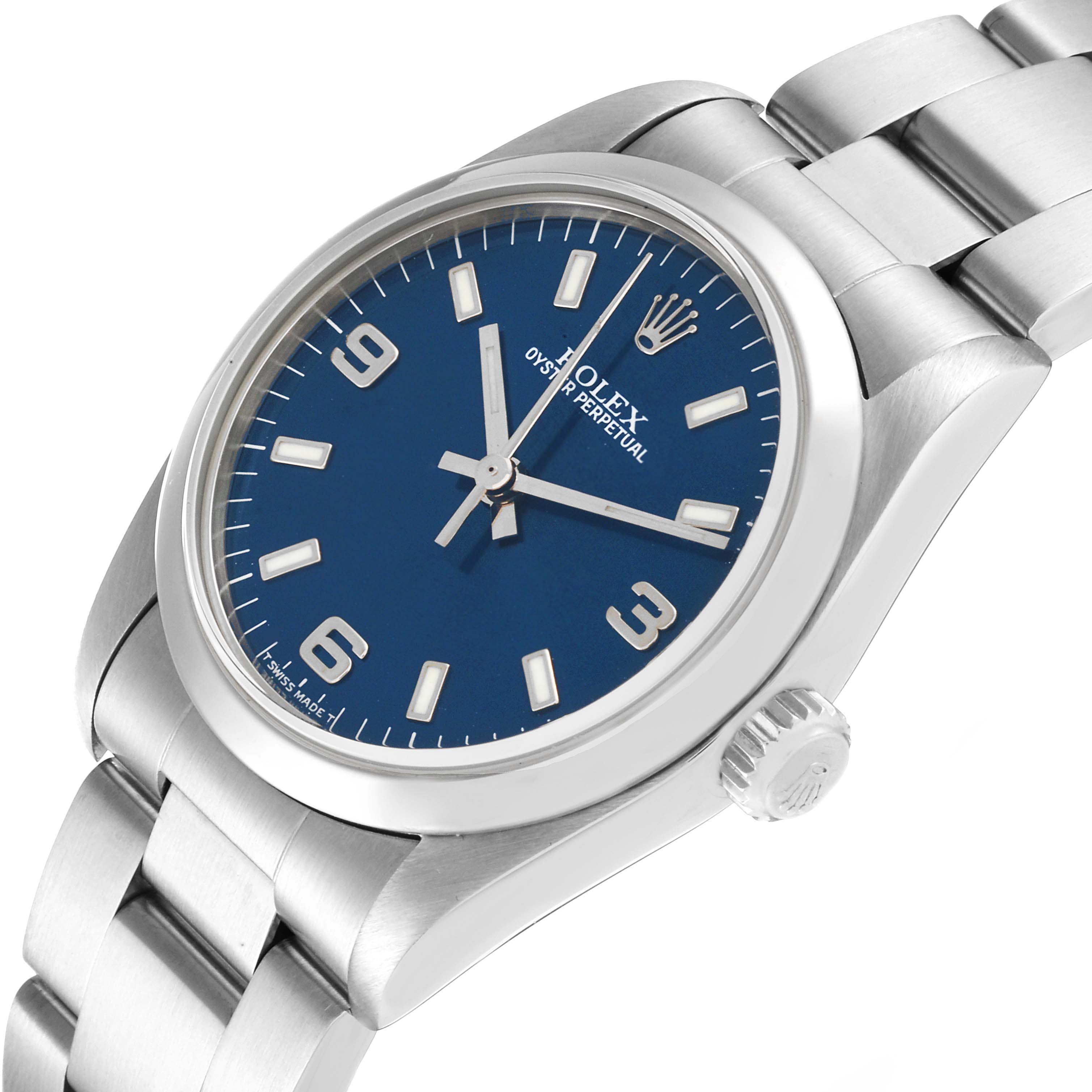 The image shows a side angle view of a Mid-Size Rolex Oyster Perpetual watch, highlighting the crown, dial, and bracelet.