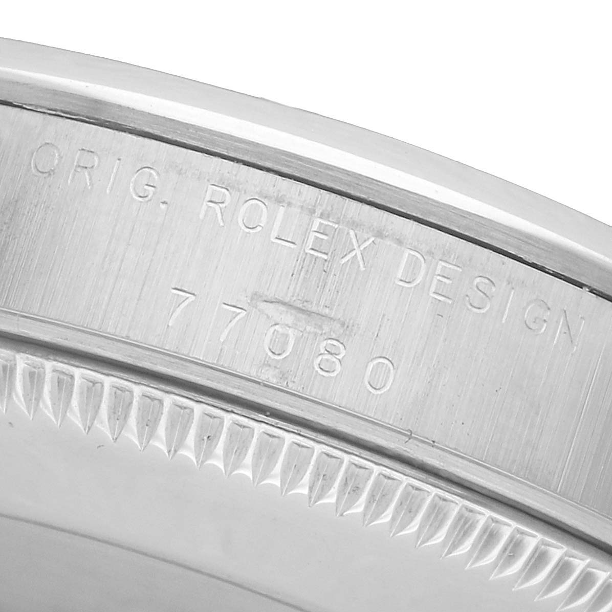 The image shows a close-up of the bezel and case side of a Rolex Mid-Size 77080 Women's Stainless Steel Black Dial watch, featuring engraved model details.