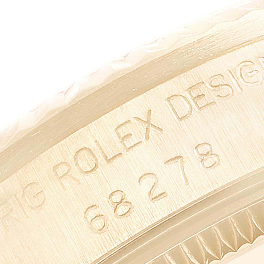 This image shows a close-up of the engraved bezel and part of the case of the Rolex President 68278 Women
s Yellow Gold Champagne Dial 68278 Women
s Yellow Gold Champagne Dial model watch.