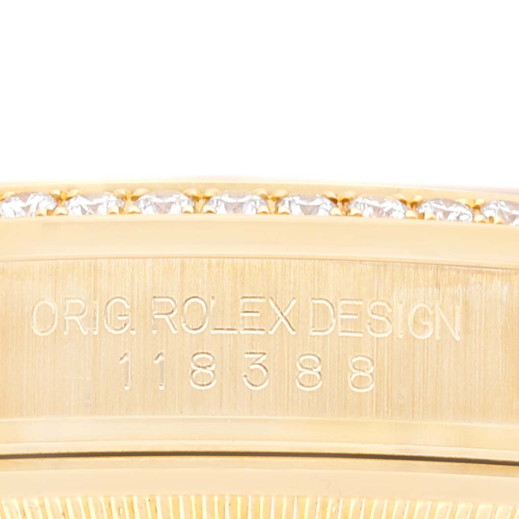 This image shows a close-up of the bezel and case of a Rolex President 118388 Men's Yellow Gold Mother of Pearl Dial 118388 Men's Yellow Gold Mother of Pearl Dial model watch, highlighting its design engraving.