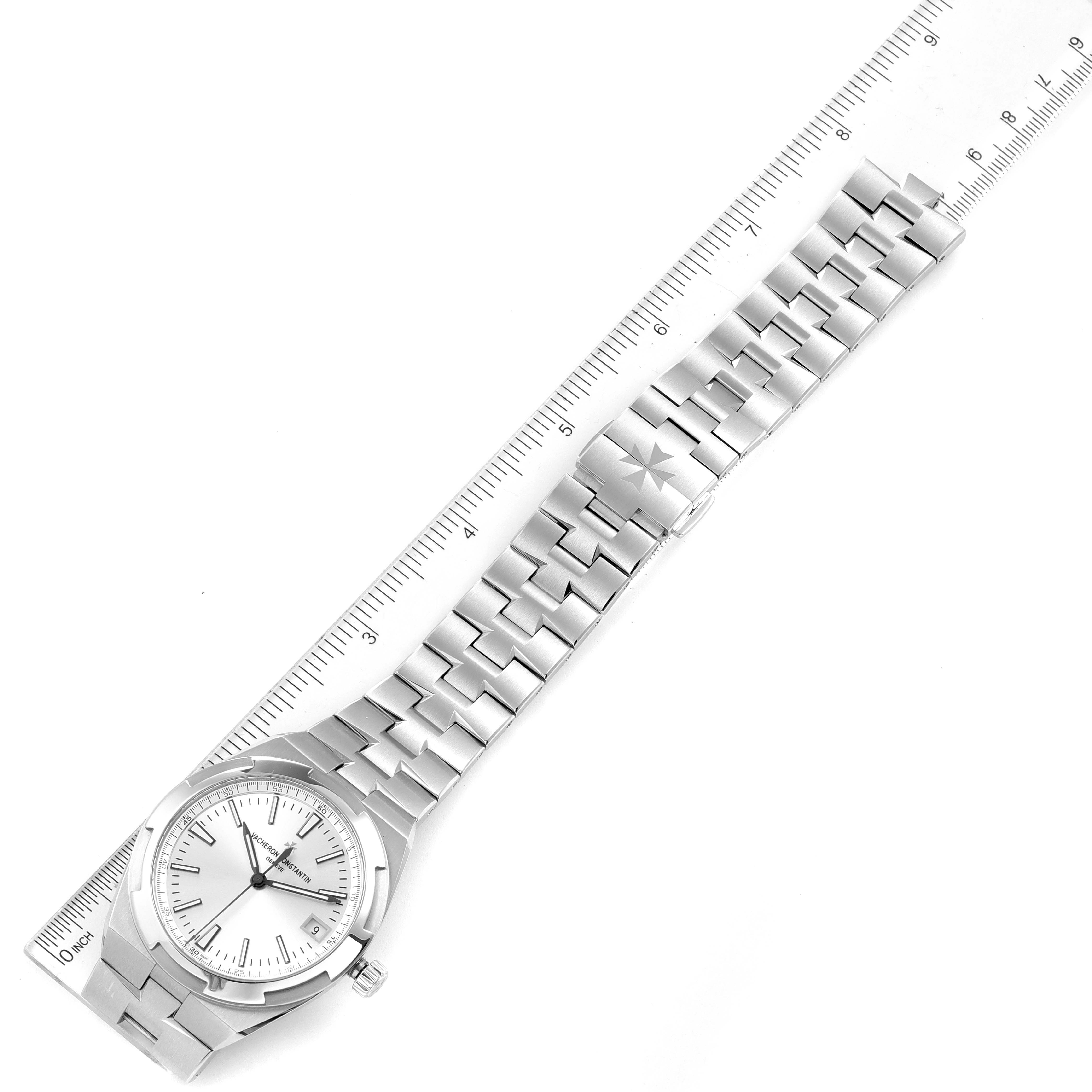 This Vacheron Constantin Overseas 4500V/110A-B126 Men
s Stainless Steel Silver Dial 4500V/110A-B126 Men
s Stainless Steel Silver Dial watch is shown from a top-down angle, displaying its face, crown, and full bracelet alongside a ruler for scale.