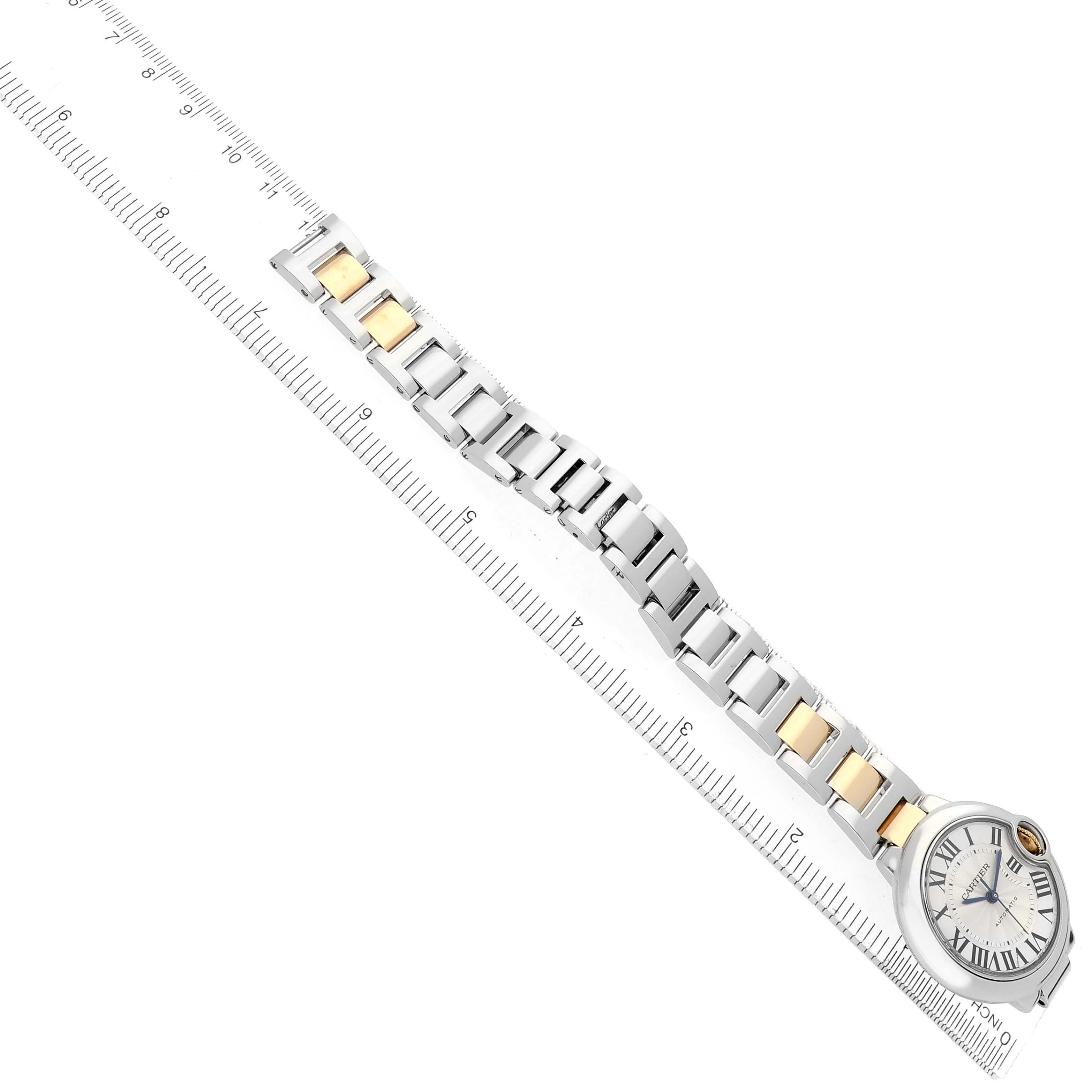 The image shows a Cartier Ballon Bleu W2BB0002 Women's Steel and Gold (two tone) Silver Dial watch at a diagonal angle, highlighting the stainless steel and gold bracelet alongside a ruler.