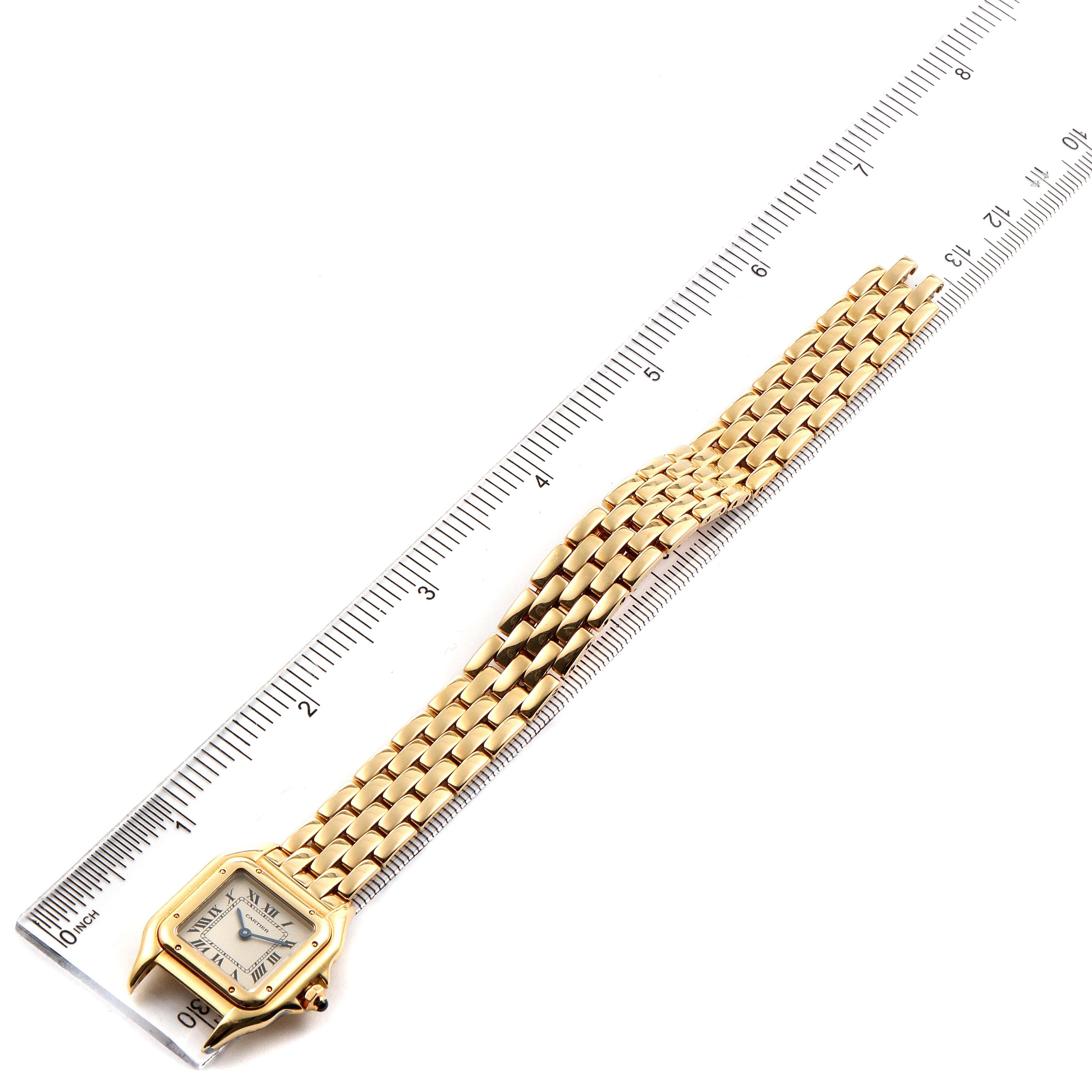 The image shows a Cartier Panthere W25022B9 Women's Yellow Gold Silver Dial W25022B9 Women's Yellow Gold Silver Dial model watch laying flat, with its face and gold bracelet aligned against a ruler.