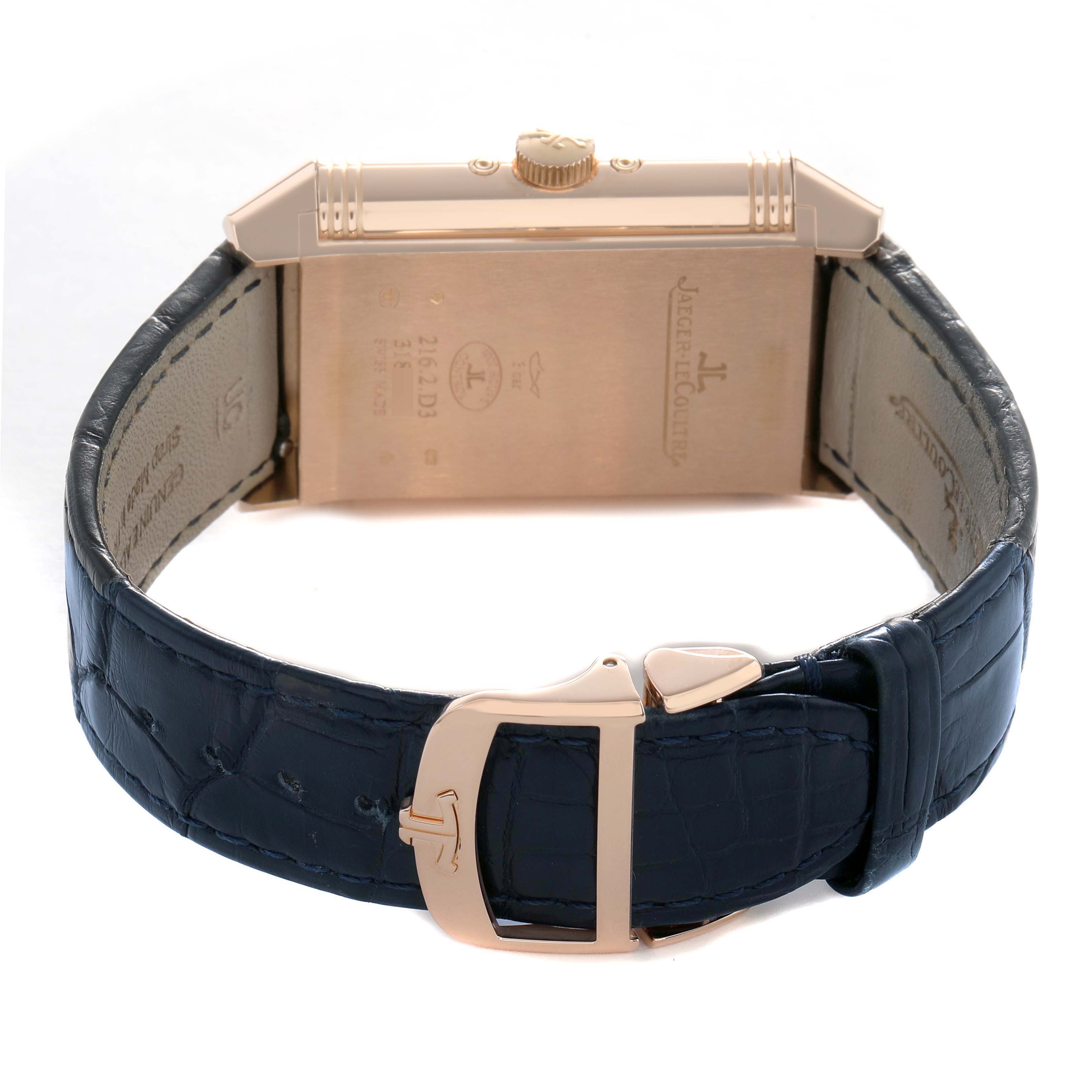 The Jaeger-LeCoultre Reverso watch is shown from the back with its strap and clasp visible.
