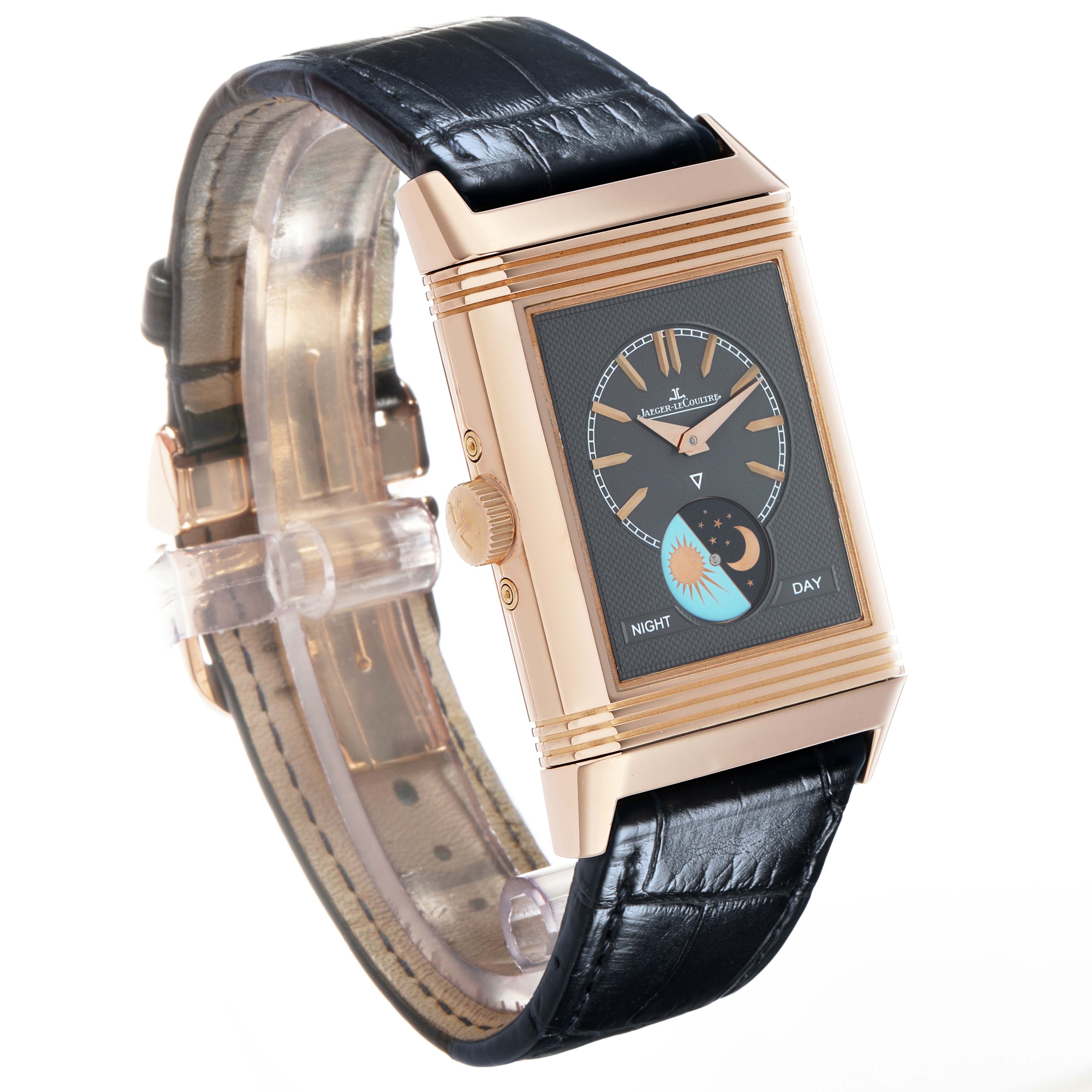 The Jaeger-LeCoultre Reverso watch is shown at an angle emphasizing its rectangular case, dial, crown, and leather strap.