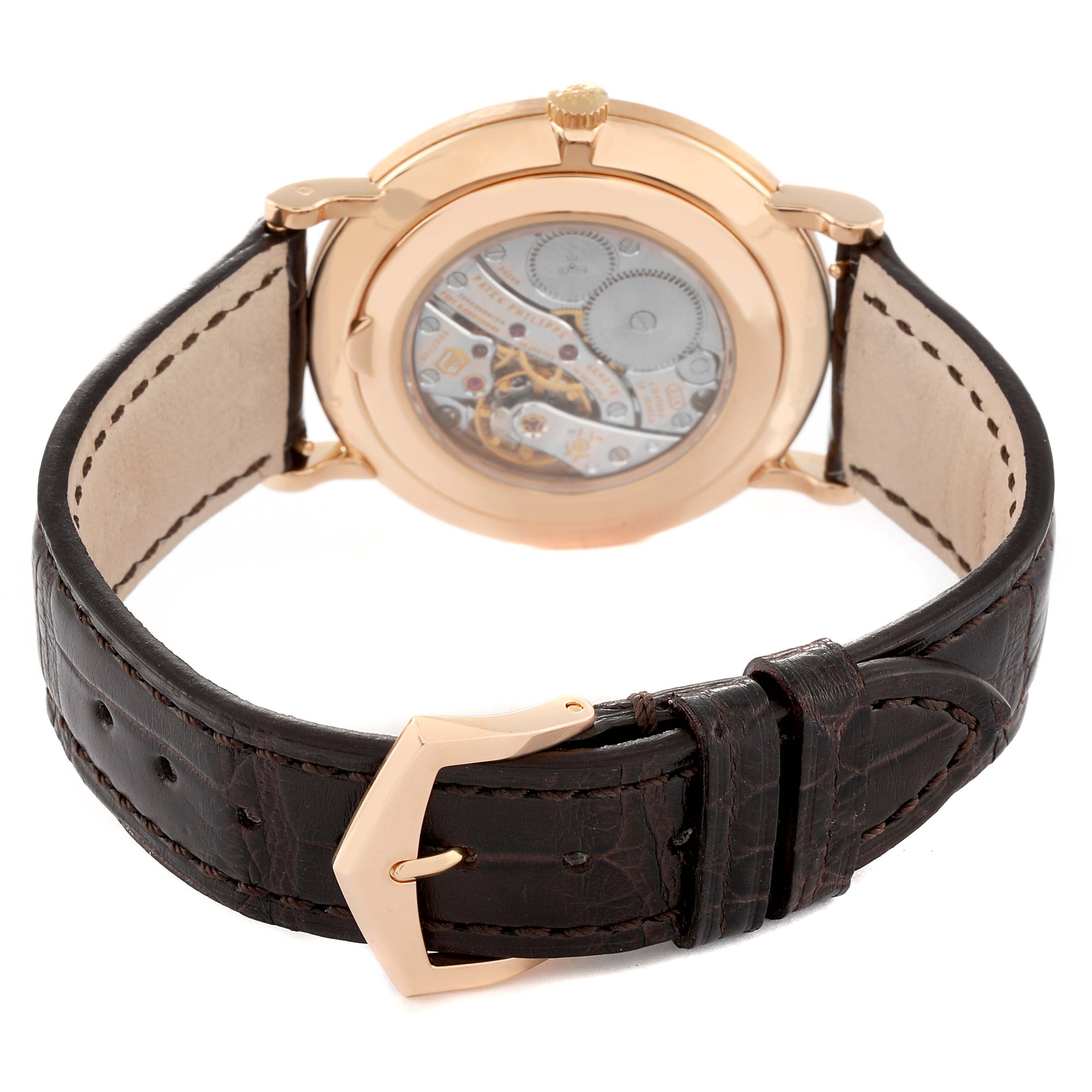 The image shows the back view of a Patek Philippe Calatrava 5119R Men
s Rose Gold White Dial 5119R Men
s Rose Gold White Dial watch highlighting its movement and leather strap.