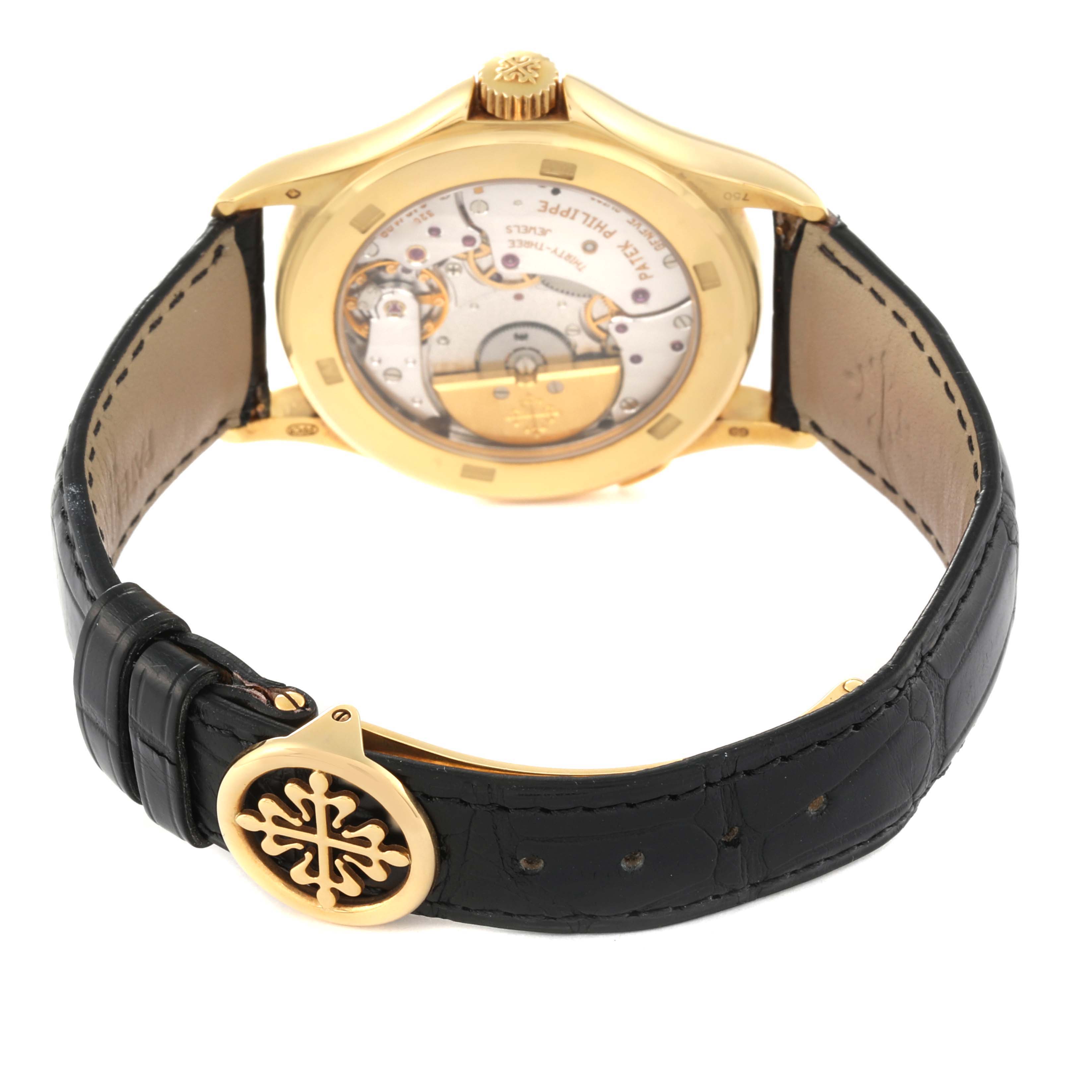 The image shows the back view of the Patek Philippe Complications 5110J Men's Yellow Gold Silver Dial 5110J Men's Yellow Gold Silver Dial watch, highlighting the inner mechanism and leather strap.