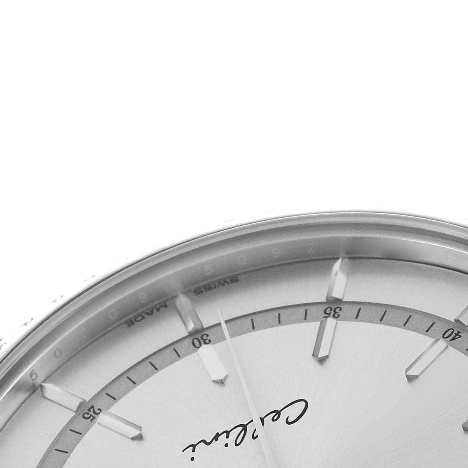 The image shows a close-up of the upper part of the dial on a Rolex Cellini 50709 Men's White Gold Silver Dial watch, featuring markers and a partial view of the logo.