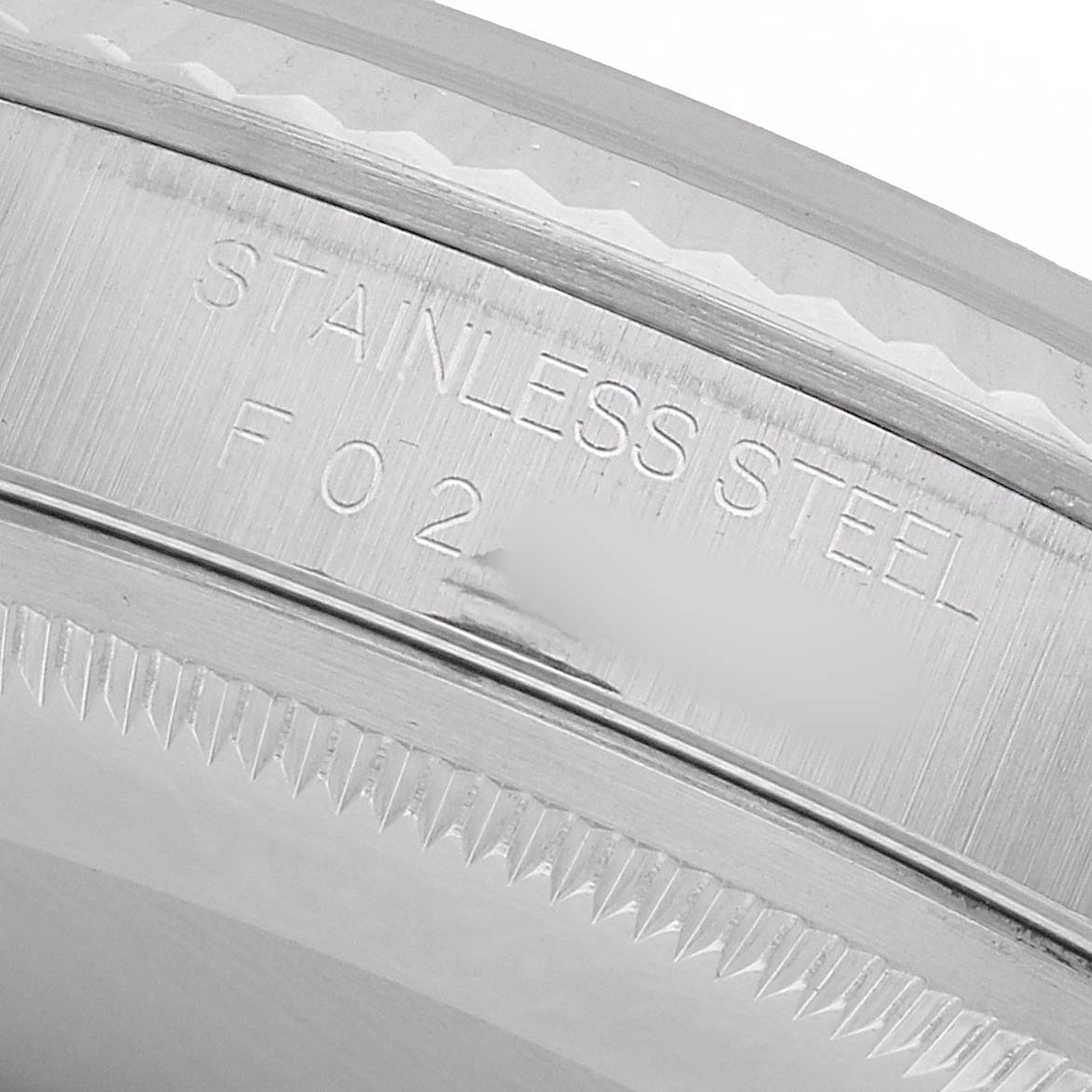 The image shows a close-up angle of the Rolex Datejust 16234 Men's Stainless Steel Pink Dial's stainless steel bezel, highlighting its engravings and serrations.