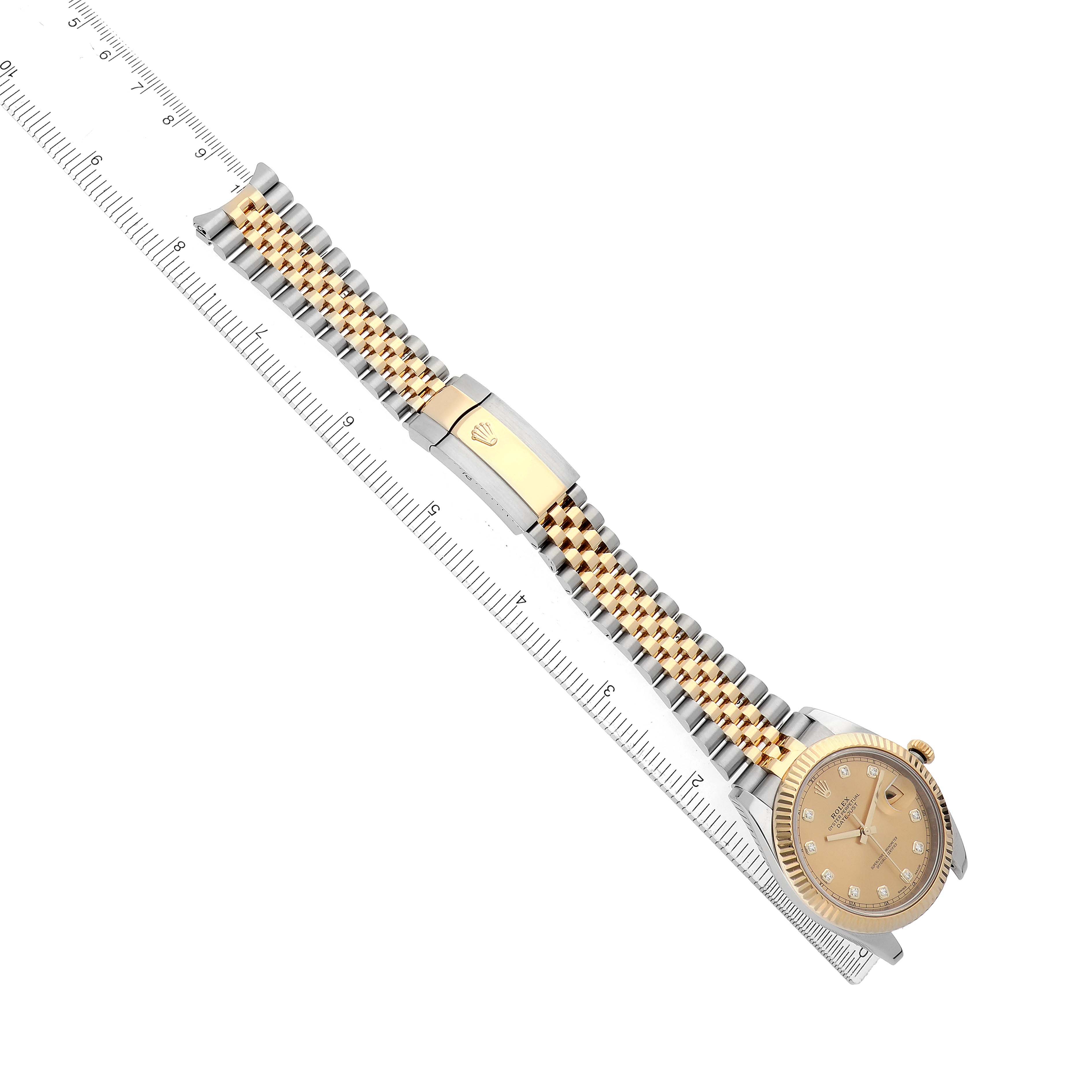 The Rolex Datejust 41 126333 Men's Steel and Gold (two tone) Champagne Dial watch is shown lying flat with a focus on the gold and silver bracelet and its clasp, alongside a ruler.