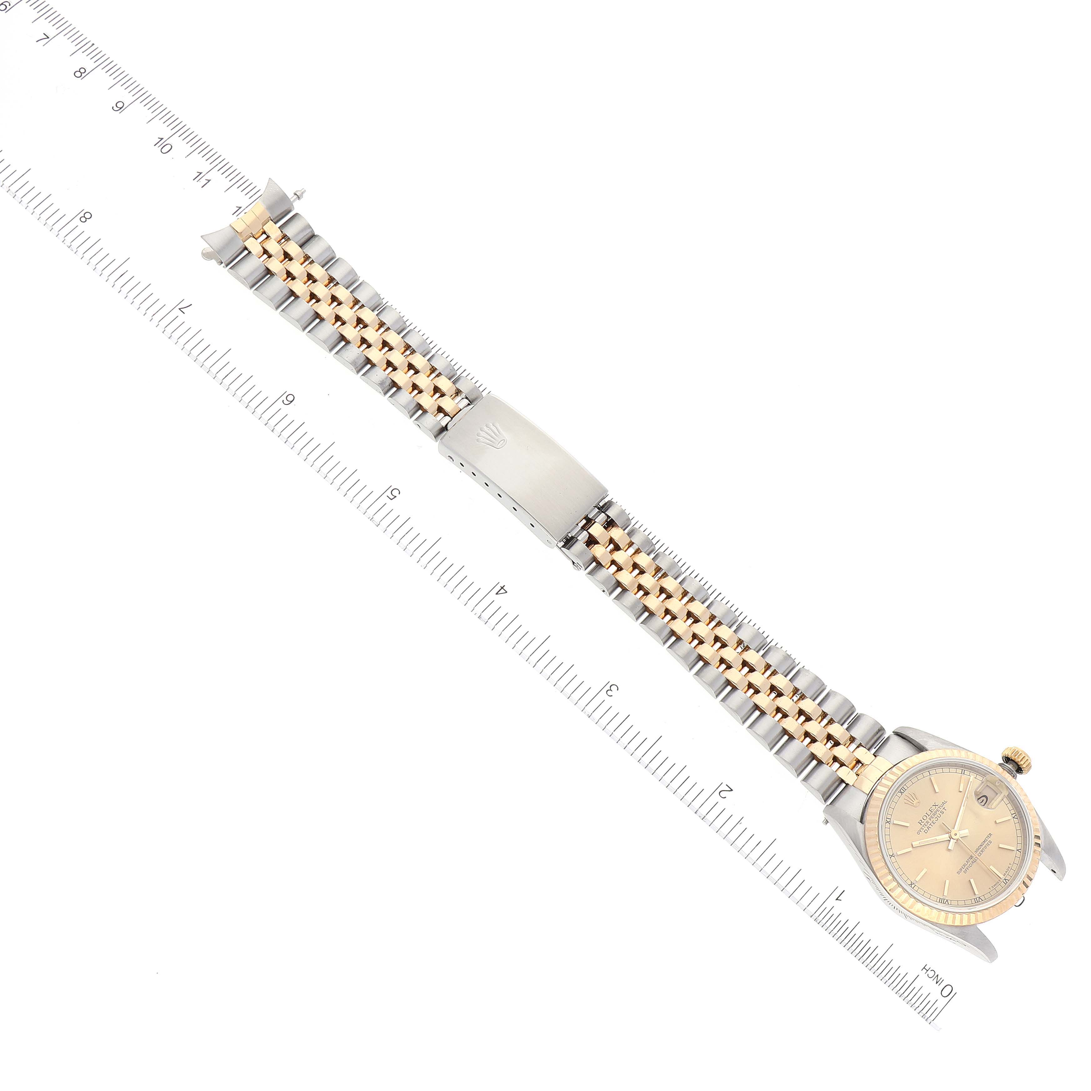 The image shows a top-down view of a Mid-Size Rolex watch and its bracelet, aligned with a ruler for scale.