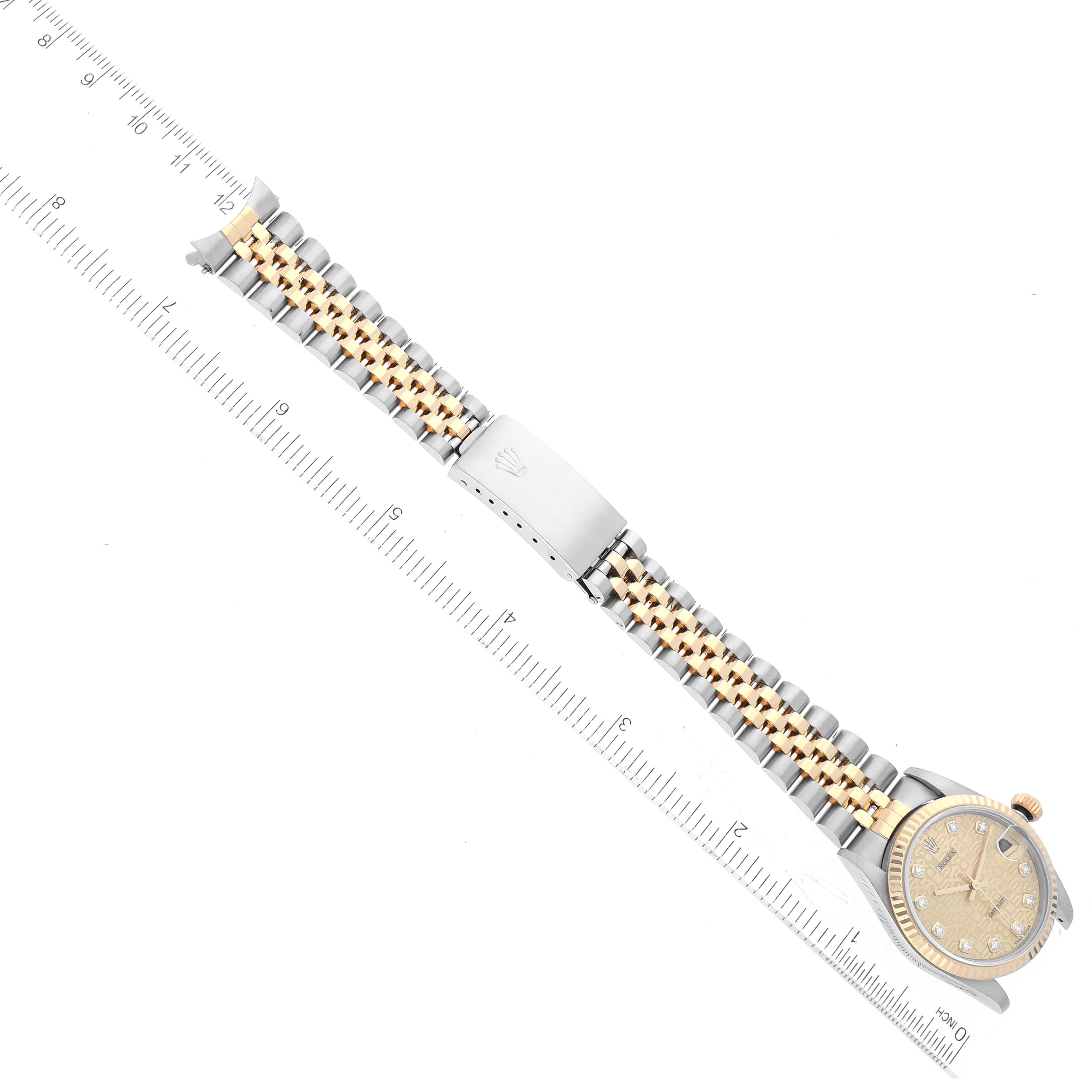 The image shows a top-down view of a Mid-Size Rolex watch, highlighting the dial, bezel, and bracelet against a ruler backdrop.