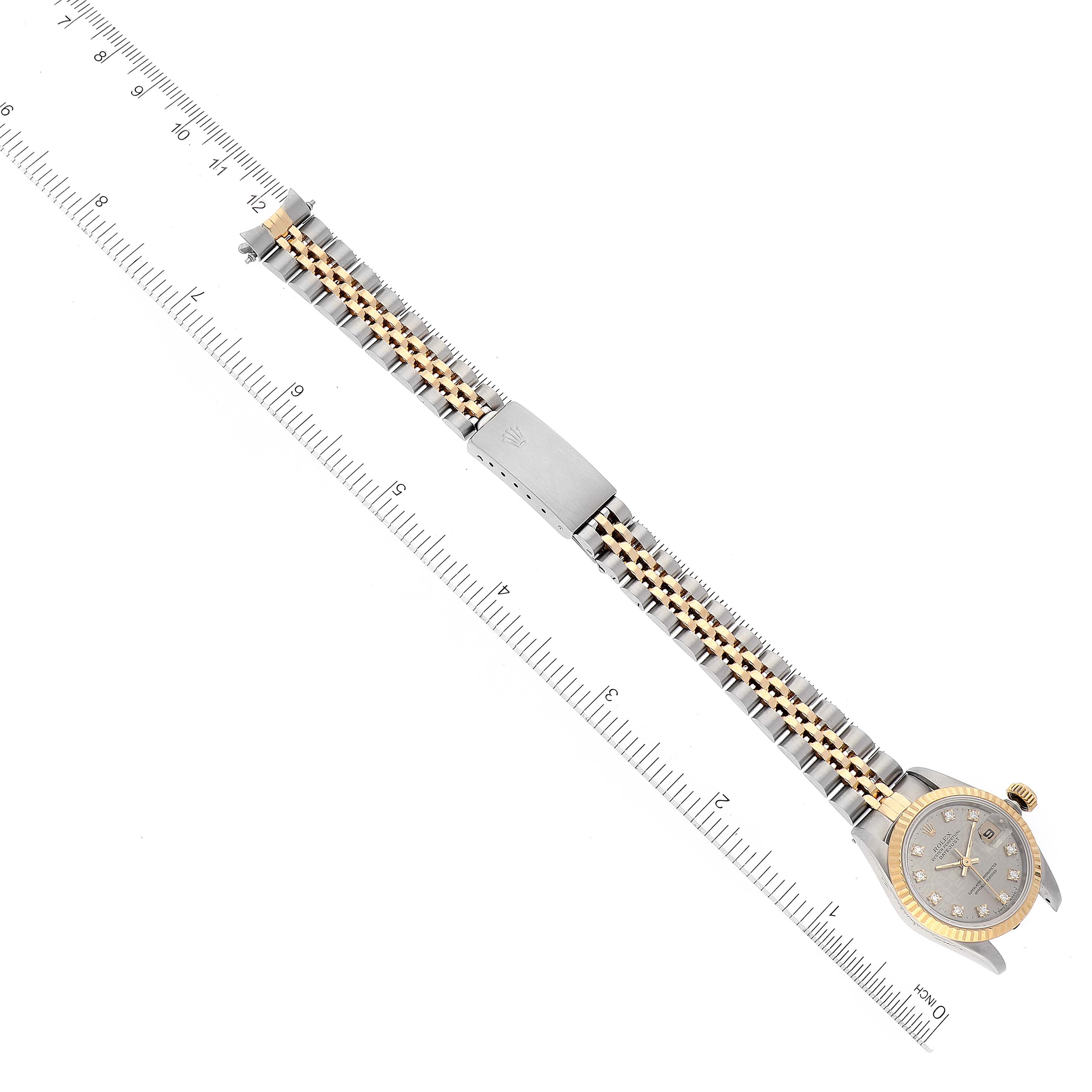 The image shows a top view of a Rolex Datejust 69173 Women's Steel and Gold (two tone) Silver Dial 69173 Women's Steel and Gold (two tone) Silver Dial watch laid along a ruler, highlighting its bracelet and watch face.