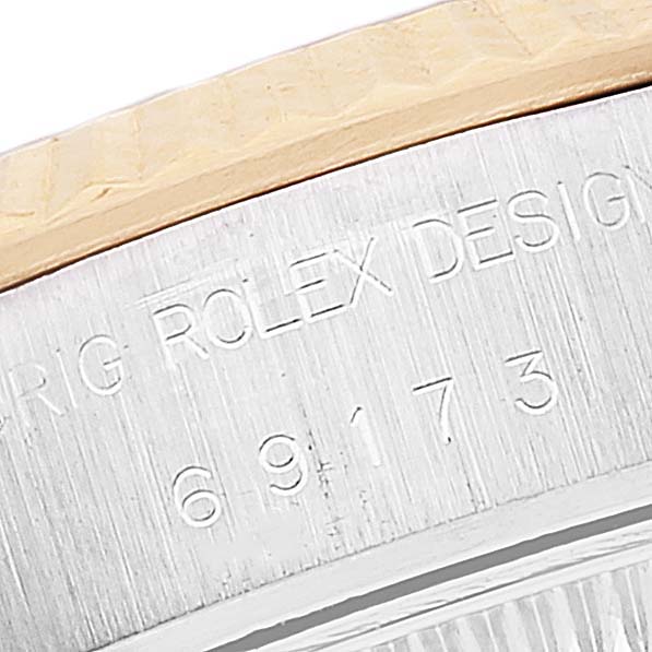 This close-up angle shows the engraved serial number and "Rolex Datejust 69173 Women's Steel and Gold (two tone) Silver Dial 69173 Women's Steel and Gold (two tone) Silver Dial" inscription on the watch case.