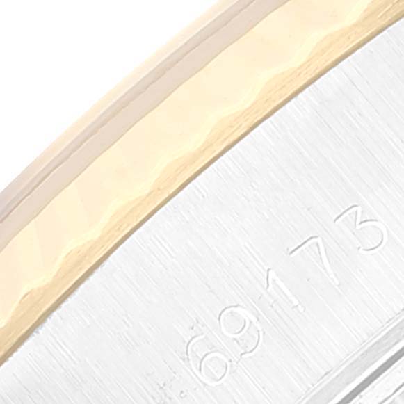 This close-up image of a Rolex Datejust 69173 Women
s Steel and Gold (two tone) Grey Dial 69173 Women
s Steel and Gold (two tone) Grey Dial watch shows the edge of the case with part of the bezel and serial number engraving.