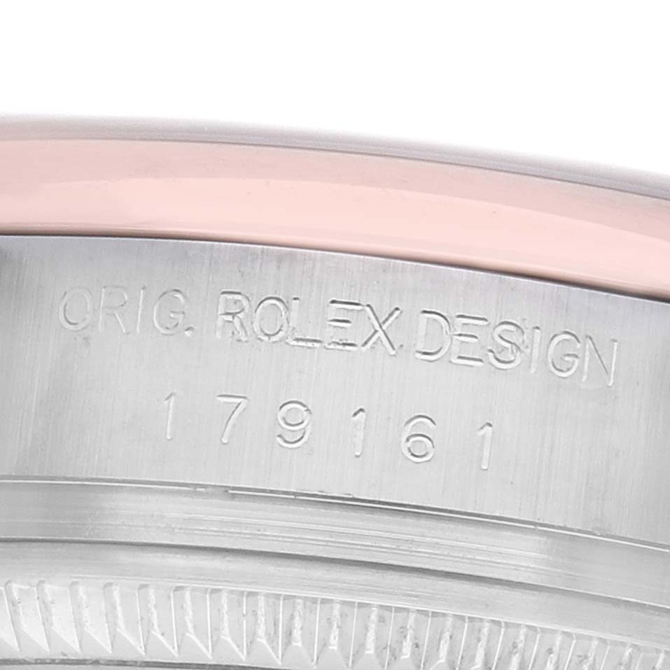 The image shows a close-up of the side view of a Rolex Datejust 179161 Women's Steel and Gold (two tone) Pink Dial, highlighting the engraved model number and bezel.