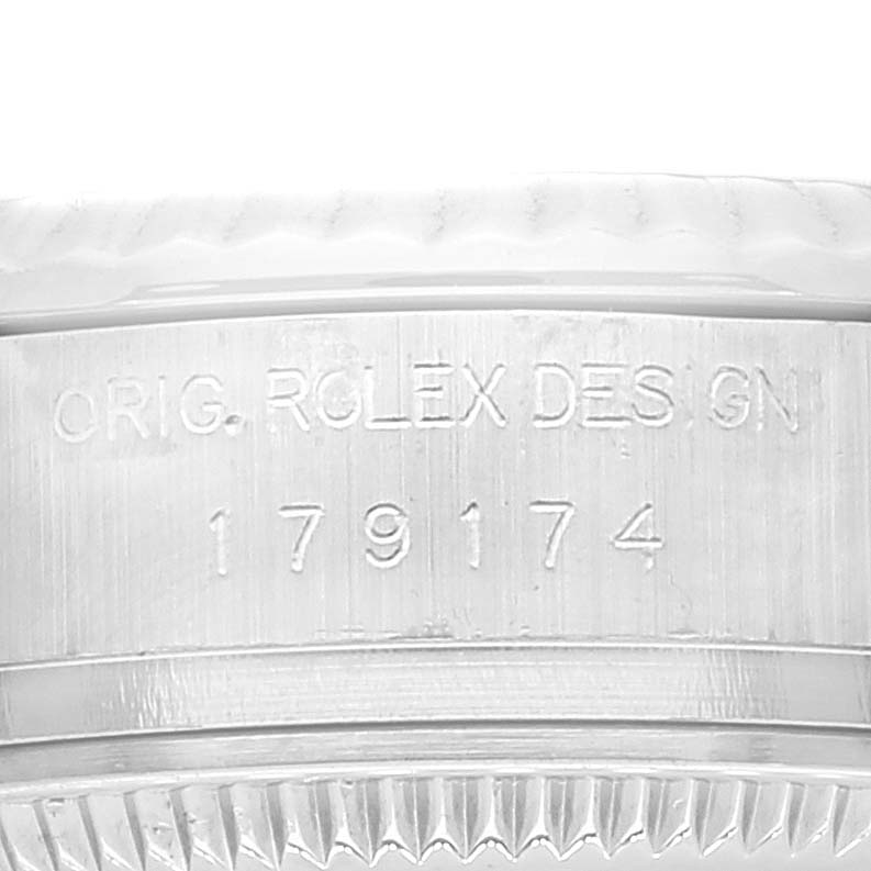 Close-up of the Rolex Datejust 179174 Women's Stainless Steel Silver Dial 179174 Women's Stainless Steel Silver Dial's inner case engraving and part of the fluted bezel, featuring the serial number and design inscription.
