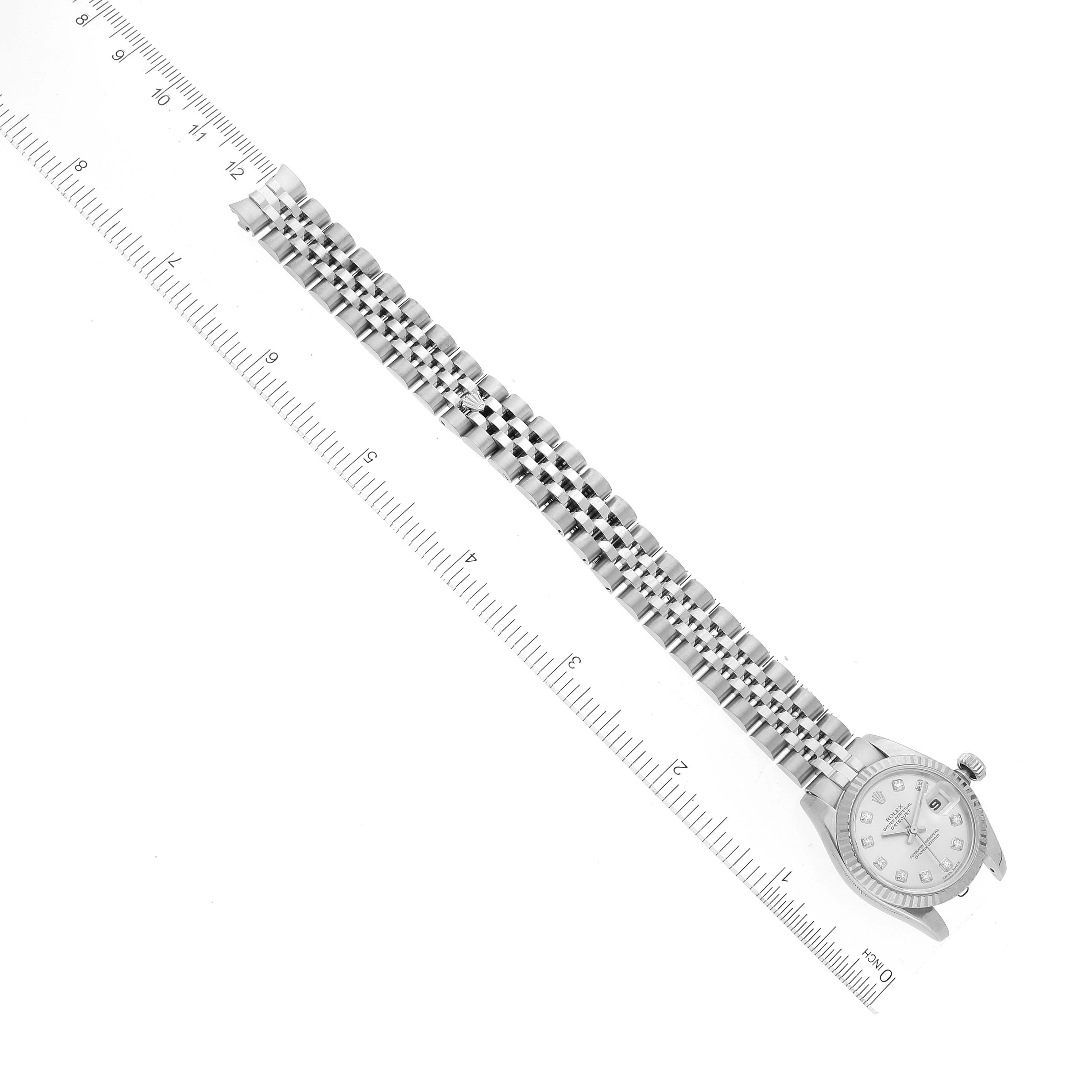 The image shows a top-down view of a Rolex Datejust 179174 Women's Stainless Steel Silver Dial 179174 Women's Stainless Steel Silver Dial watch with its full metal bracelet laid along a ruler.