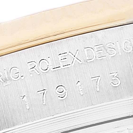 A close-up angle showing the engraved model and serial numbers on the case rim of a Rolex Datejust 179173 Women's Steel and Gold (two tone) Black Dial 179173 Women's Steel and Gold (two tone) Black Dial watch.