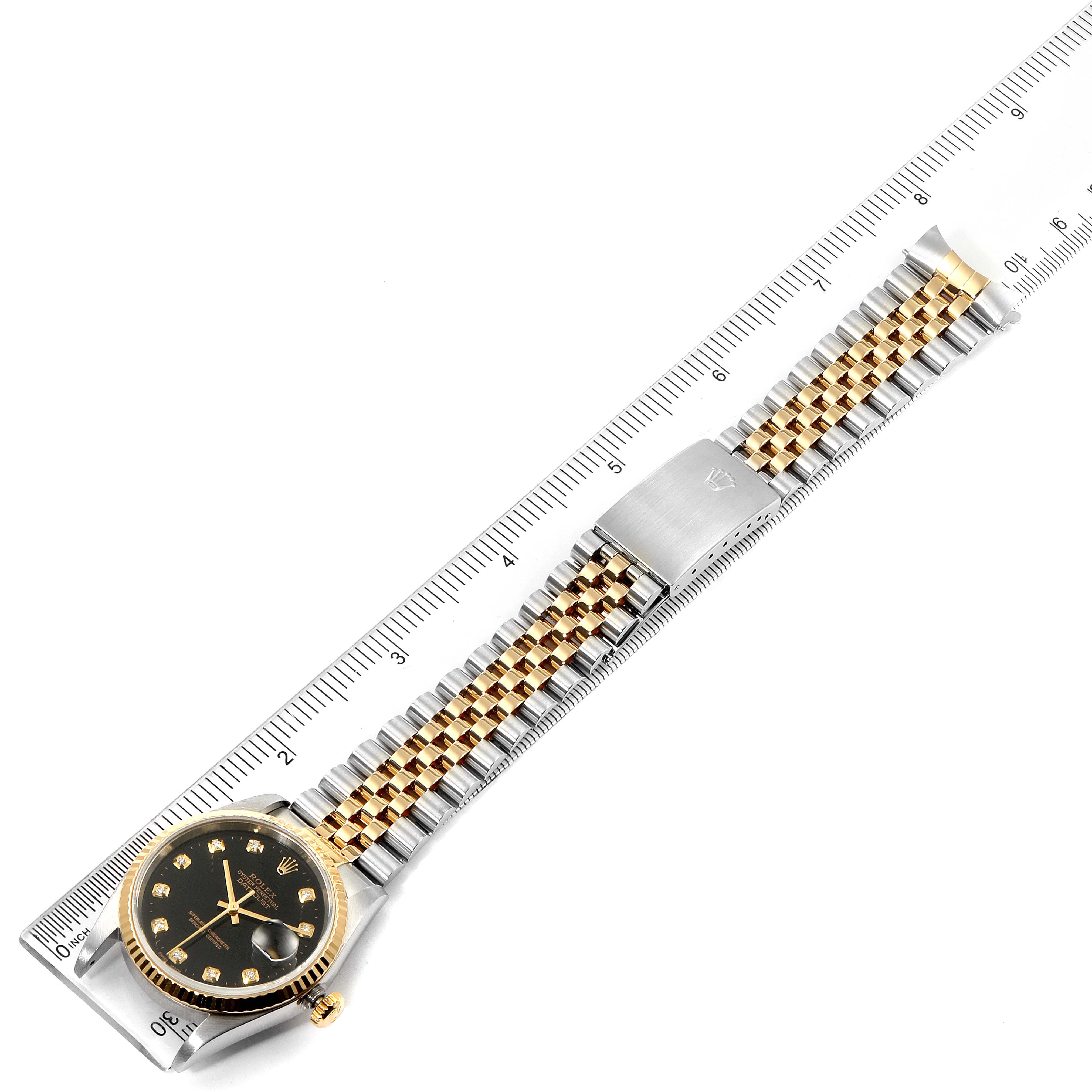 The image shows a Rolex Datejust 16233 Men's Steel and Gold (two tone) Black Dial 16233 Men's Steel and Gold (two tone) Black Dial watch laid flat with its band extended, measured against a ruler.