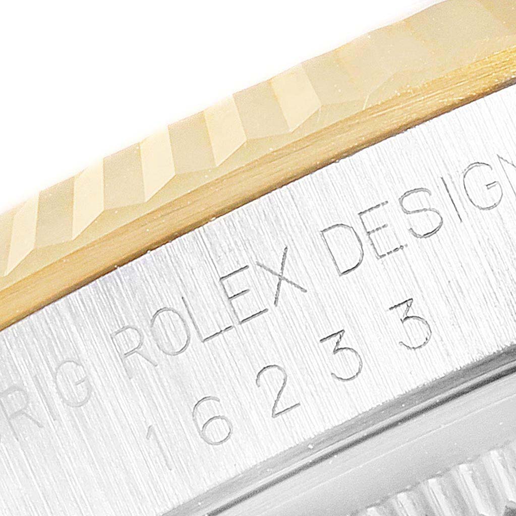 The image shows a close-up of the Rolex Datejust 16233 Men's Steel and Gold (two tone) Black Dial 16233 Men's Steel and Gold (two tone) Black Dial's fluted bezel and engraved case side with the model number 16233.