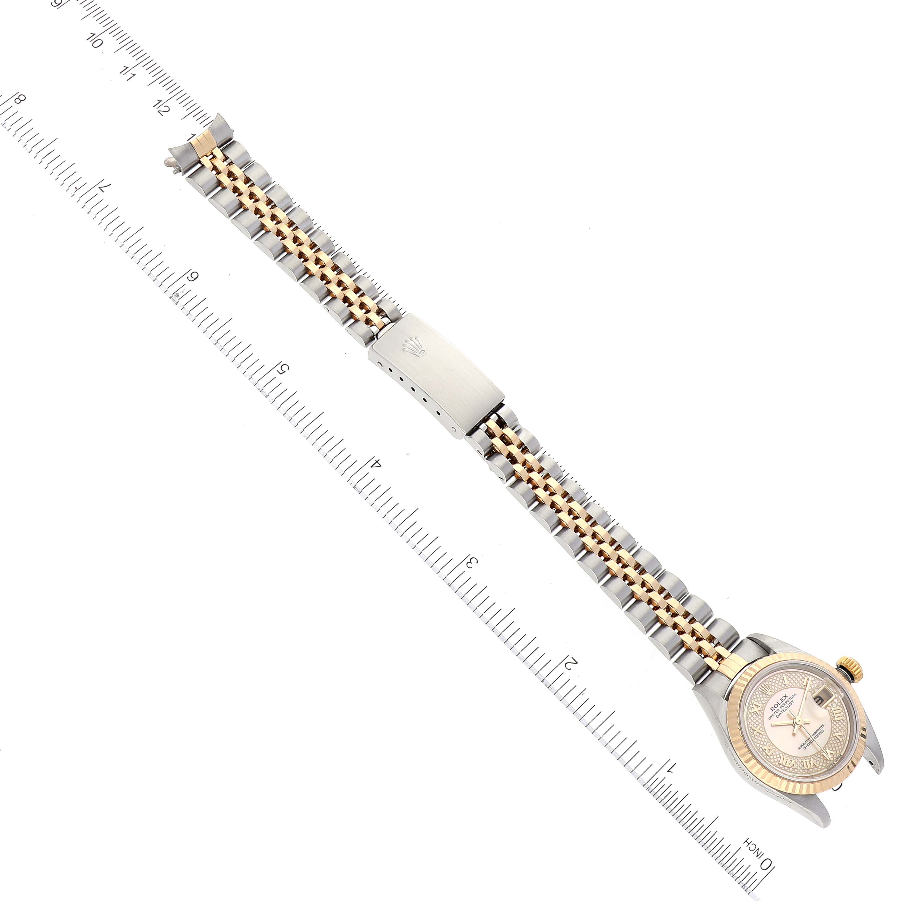 The Rolex Datejust 79173 Women's Steel and Gold (two tone) Mother of Pearl Dial 79173 Women's Steel and Gold (two tone) Mother of Pearl Dial watch is shown at an angle, displaying the full bracelet and the dial, with a ruler for scale.