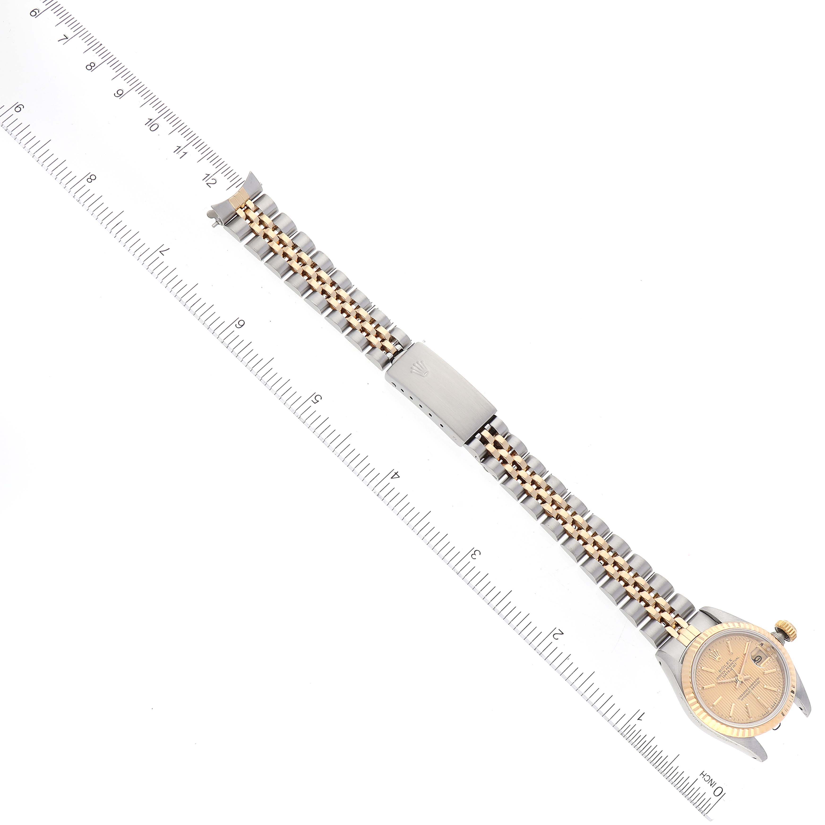 The image shows a Rolex Datejust 69173 Women's Steel and Gold (two tone) Champagne Dial 69173 Women's Steel and Gold (two tone) Champagne Dial watch laid flat with the entire bracelet and clasp visible, alongside a ruler for scale.