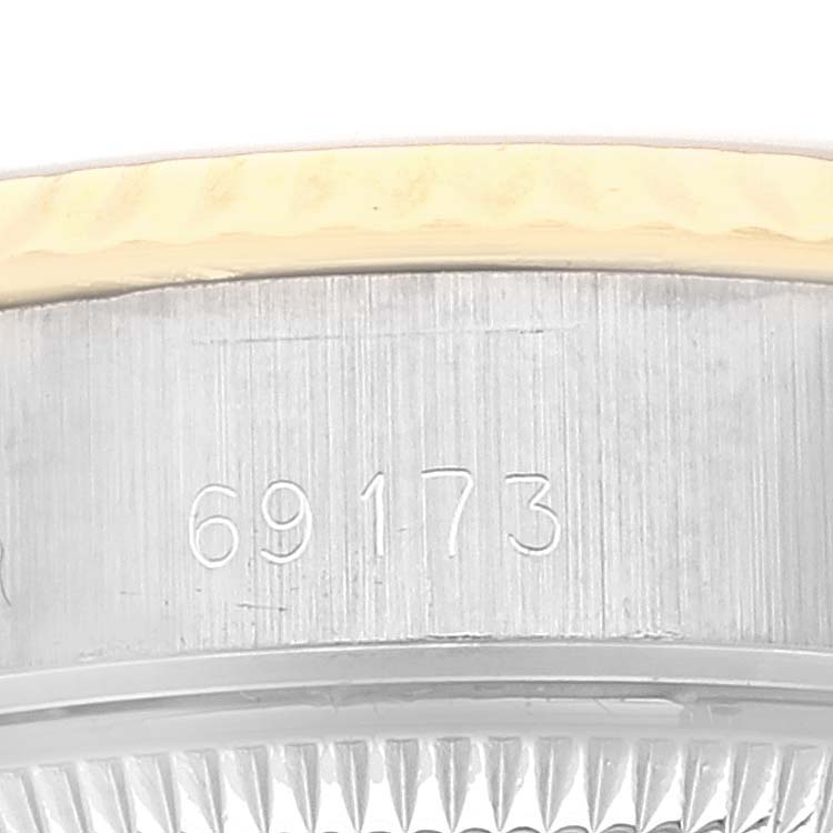 The image shows a close-up of the Rolex Datejust 69173 Women's Steel and Gold (two tone) Champagne Dial 69173 Women's Steel and Gold (two tone) Champagne Dial model's case side with its serial number and part of its bezel.