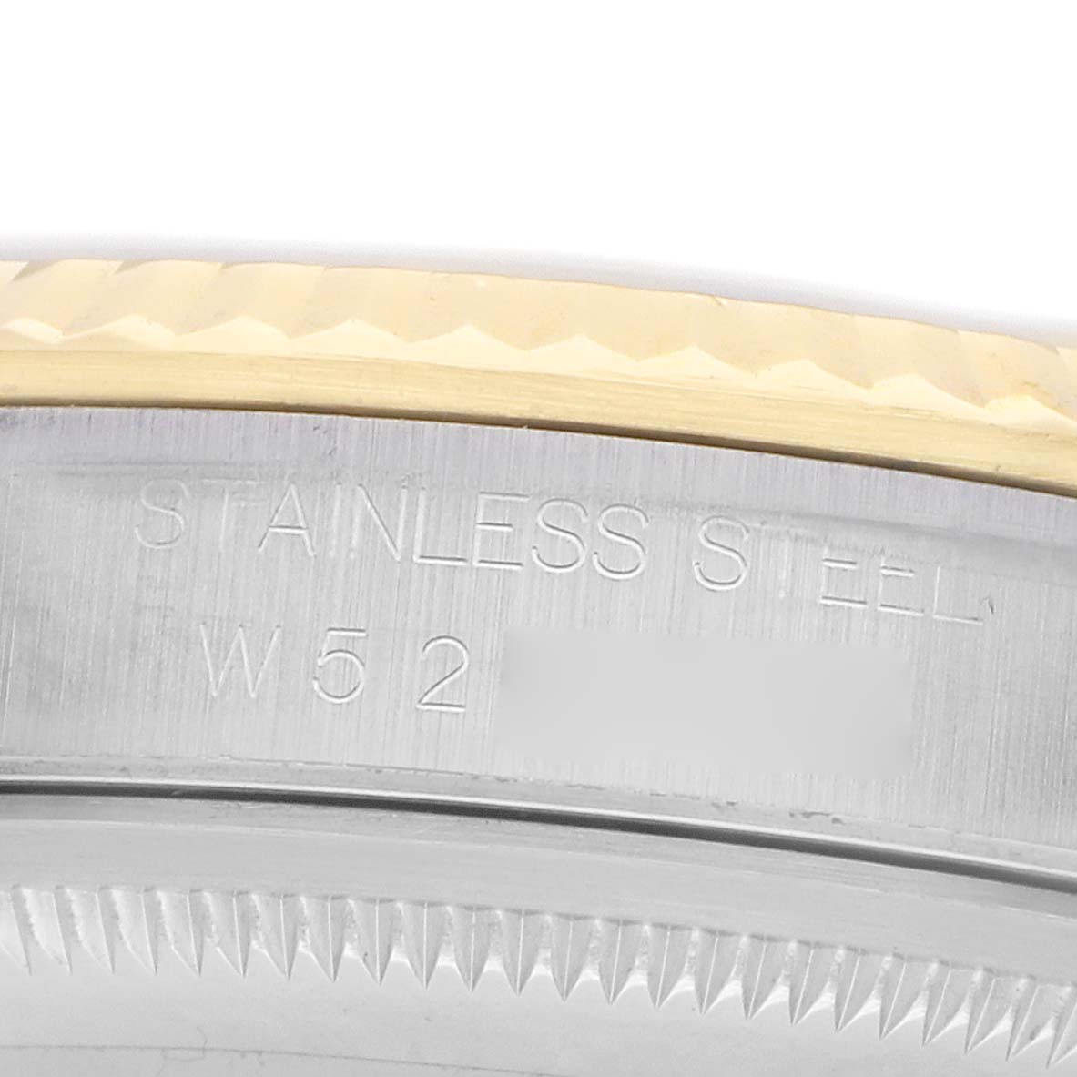 The image shows a close-up of the Rolex Datejust 16233 Men's Steel and Gold (two tone) Beige Dial's stainless steel case with engraved text and part of the fluted bezel.