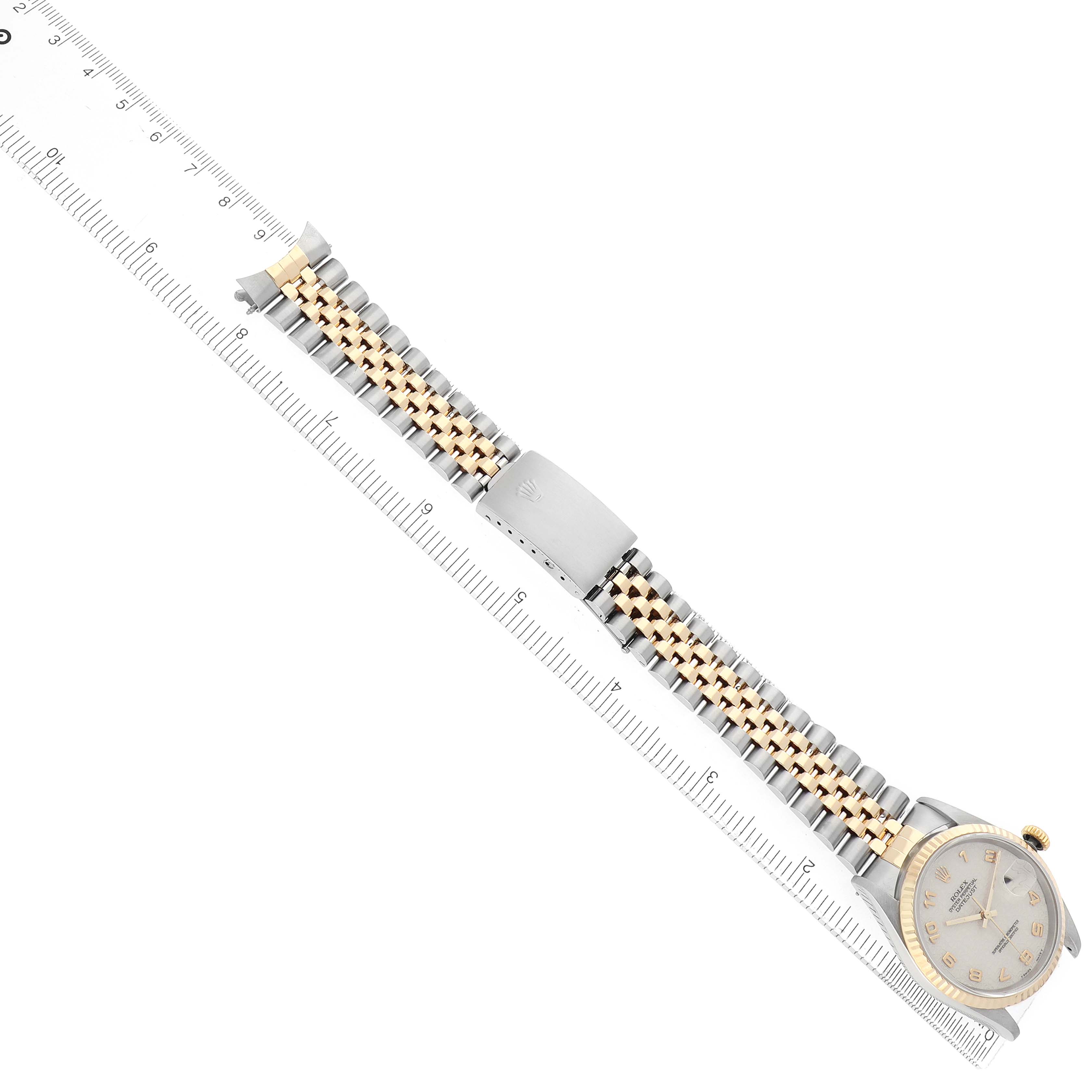 The Rolex Datejust 16233 Men's Steel and Gold (two tone) Beige Dial watch is shown at a slight angle, displaying its bracelet and clasp alongside a ruler for scale.