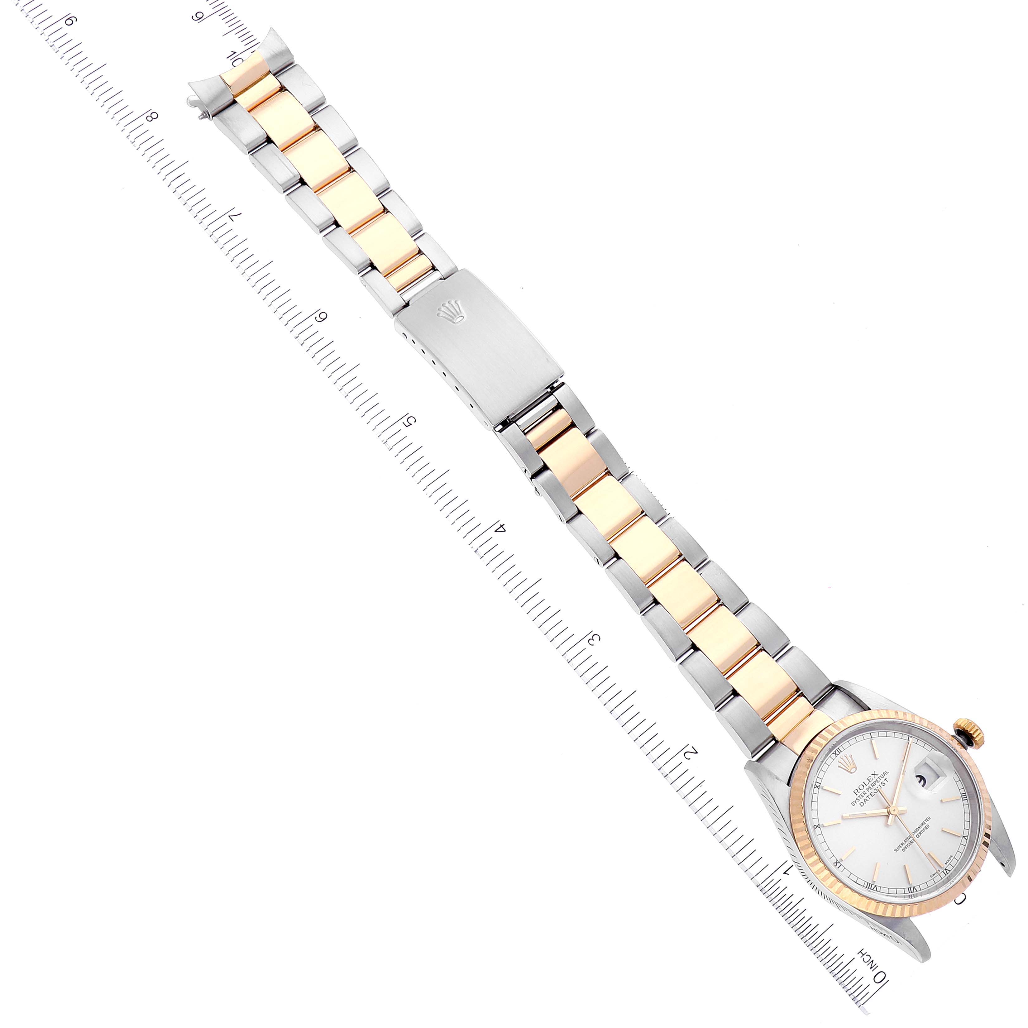 The image shows a Rolex Datejust 16233 Men's Steel and Gold (two tone) Silver Dial 16233 Men's Steel and Gold (two tone) Silver Dial watch at a top-down angle, displaying the full face, bracelet, and clasp near a ruler.