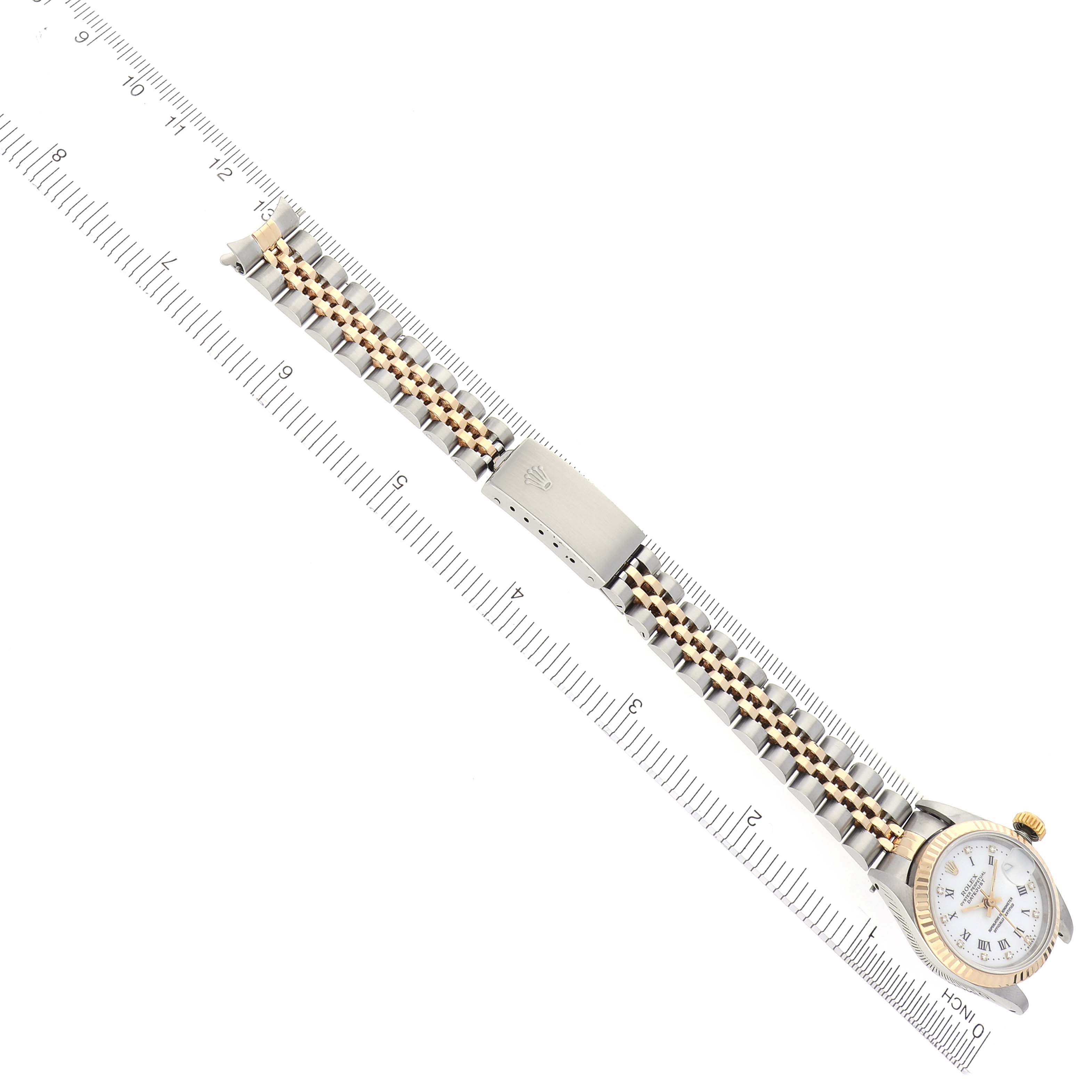 The image shows a top view of a Rolex Datejust 69173 Women's Steel and Gold (two tone) White Dial 69173 Women's Steel and Gold (two tone) White Dial watch with its bracelet extended alongside a ruler.