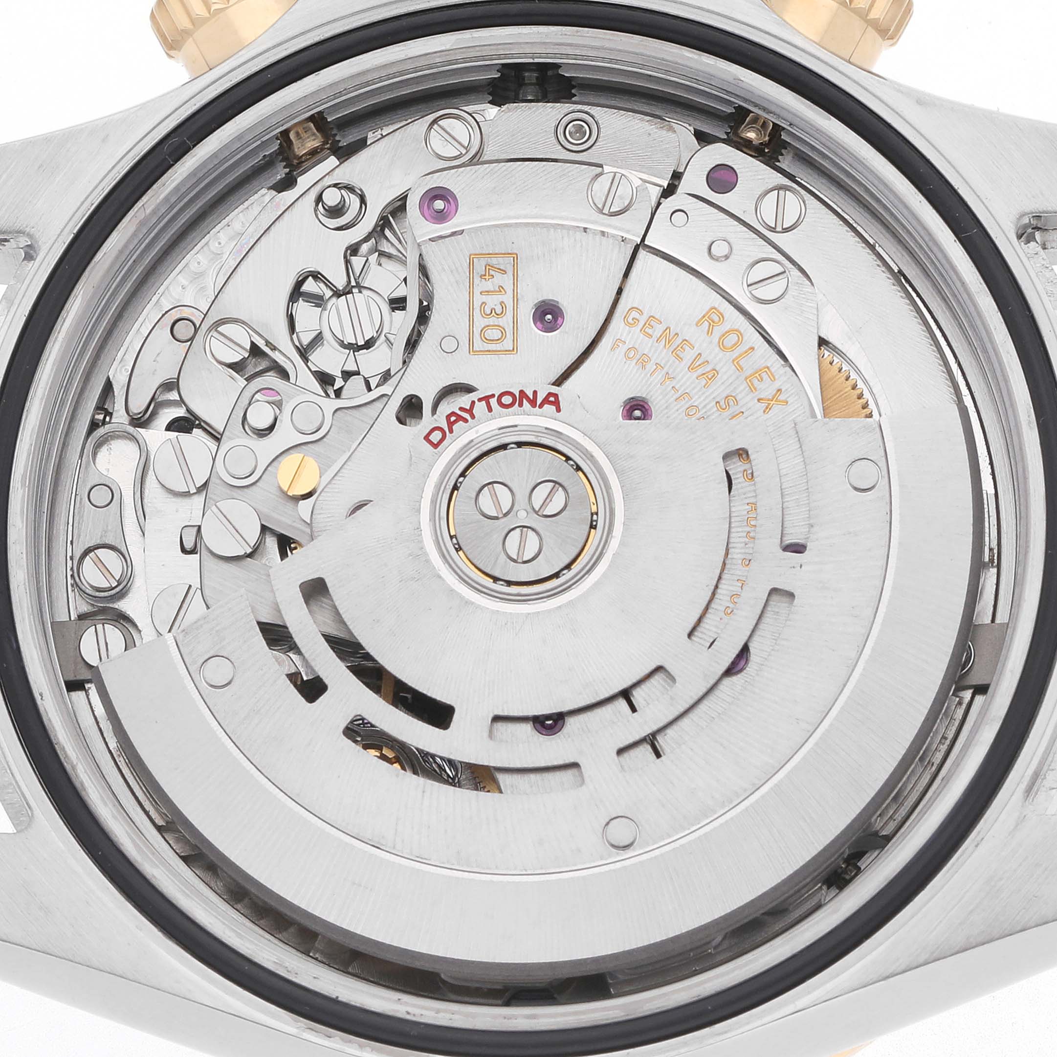 The image shows the movement mechanism of a Rolex Daytona 116523 Men's Steel and Gold (two tone) Silver Dial watch viewed from the back, featuring gears and inscriptions.