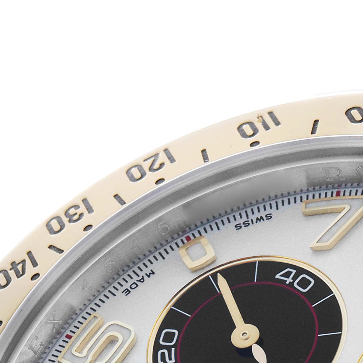 The image shows a close-up of the Rolex Daytona 116523 Men's Steel and Gold (two tone) Silver Dial watch, focusing on part of the bezel and part of the dial with numerical markings.