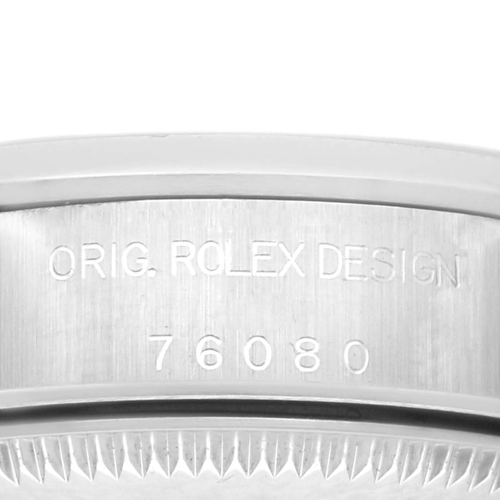The image shows the side engraving and edge of the bezel on a Rolex Oyster Perpetual 76080 Women's Stainless Steel Black Dial 76080 Women's Stainless Steel Black Dial watch, focusing on the serial number and "ORIG. ROLEX DESIGN."