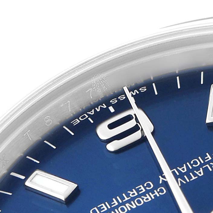 The image shows a close-up of the dial edge of a Rolex Oyster Perpetual 177200 Women's Stainless Steel Blue Dial watch with the "SWISS MADE" inscription and part of the minute and second hands.