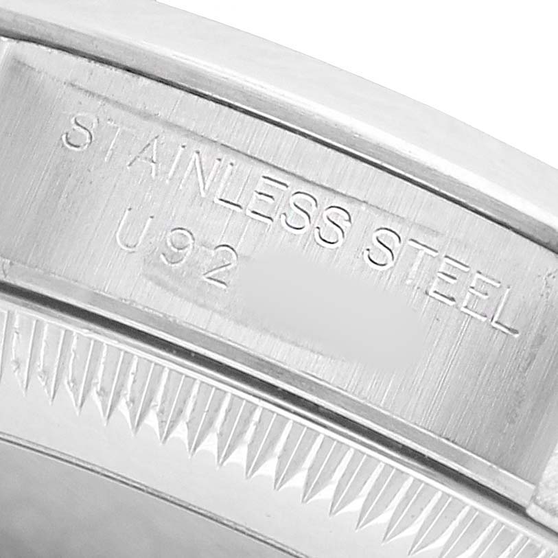 This image shows a close-up of the engraved stainless steel part of a Rolex Oyster Perpetual 67180 Women's Stainless Steel Blue Dial watch case.
